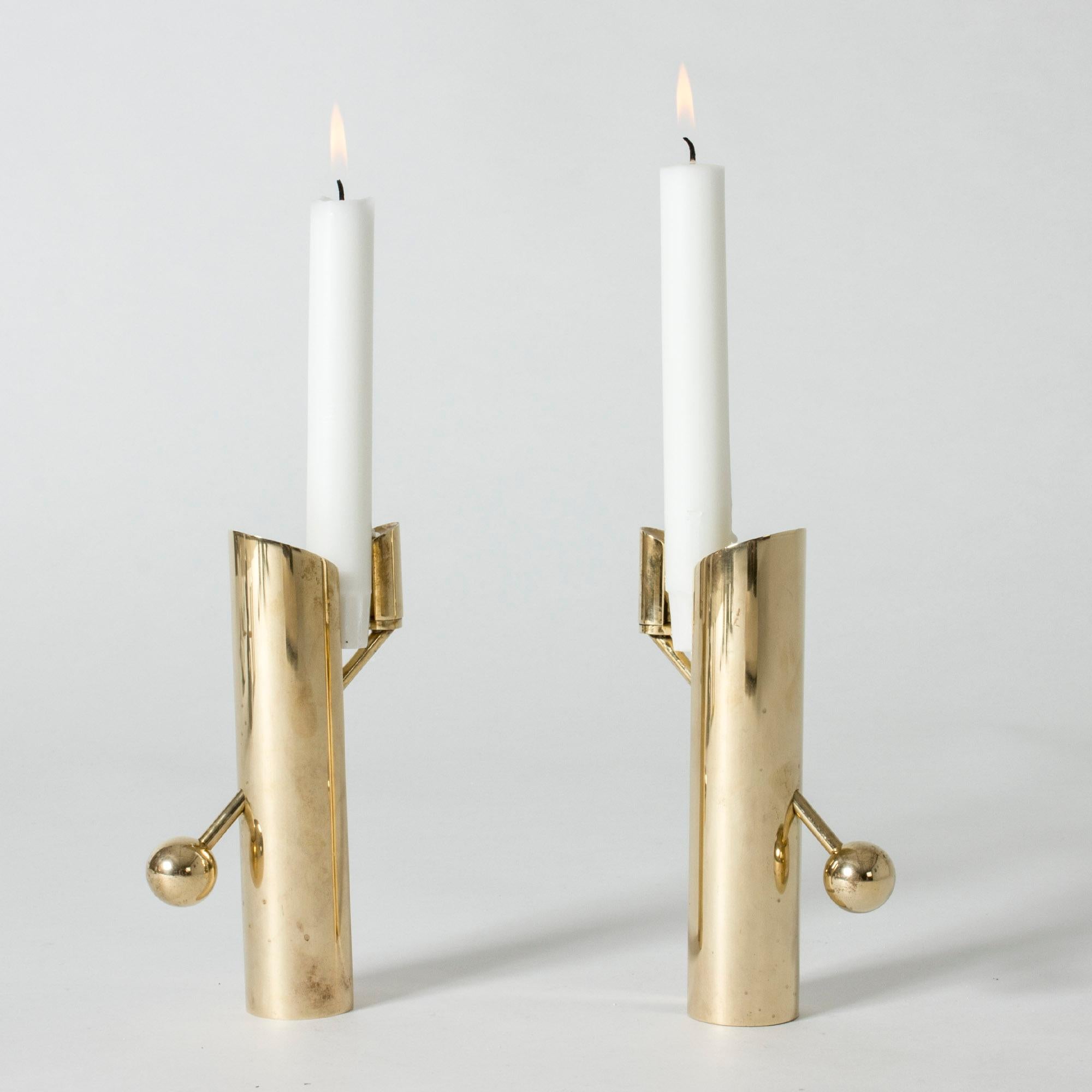 Pair of heavy, solid brass “Variabel” candlesticks by Pierre Forssell. Interesting design where the diagonal arm slides through the base to fasten the candle. The design springs from Forssell’s idea that the whole candle should be visible as it