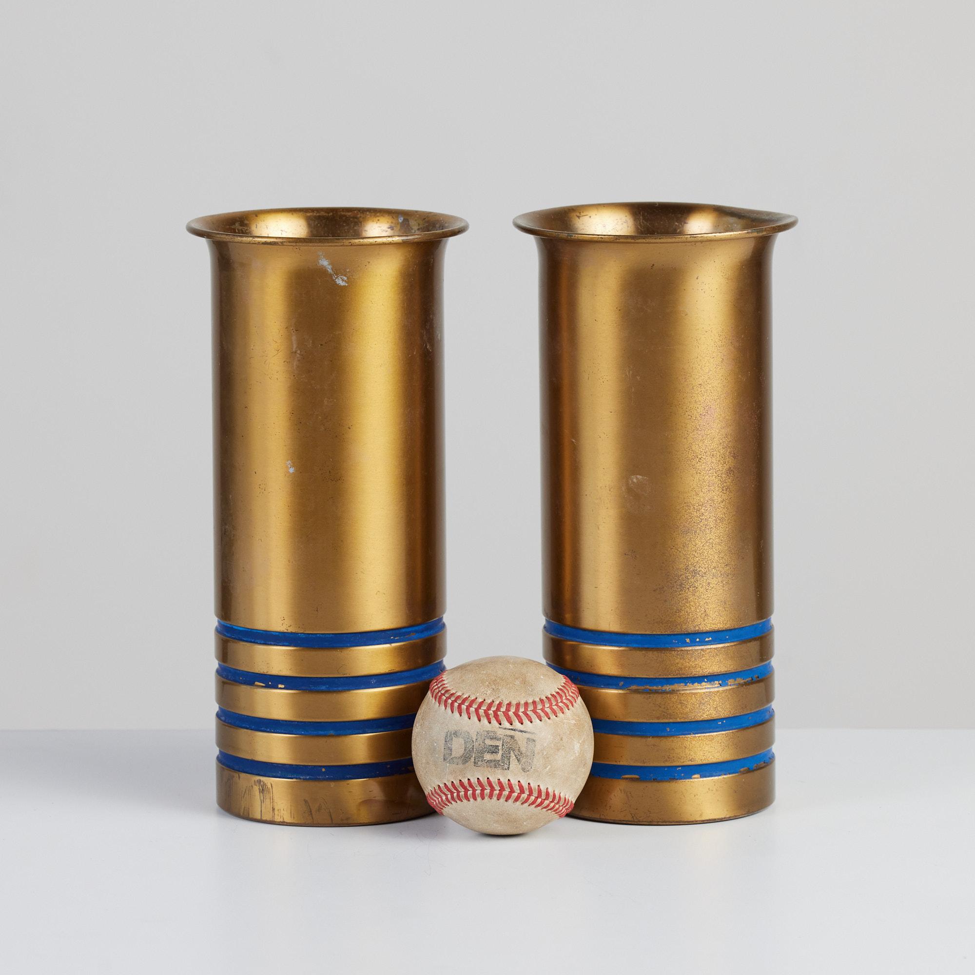 Pair of brass vases by Walter von Nessen for Chase, c.1930s, USA. The pair of solid patinated brass Art Deco vases feature a tulip opening and four incised rings around the bottom of the vessel in cobalt blue. They are impressed with [Chase] and