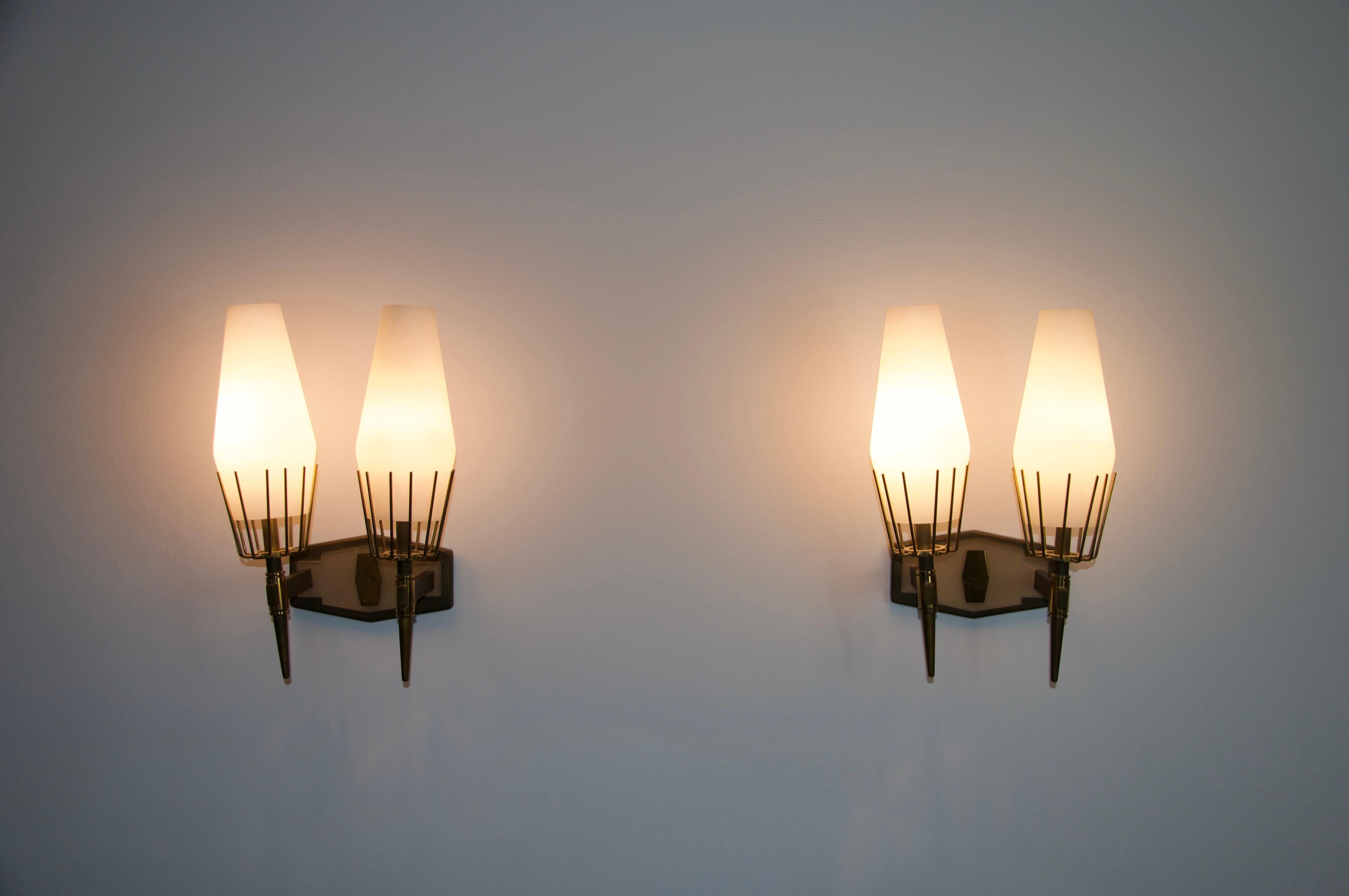 Questa squisita coppia di lampade da parete provenienti dall'Italia degli anni '60 incarna l'eleganza e la maestria del design moderno della metà del secolo. Progettate e realizzate dal rinomato produttore italiano Stilnovo, queste lampade sono dei