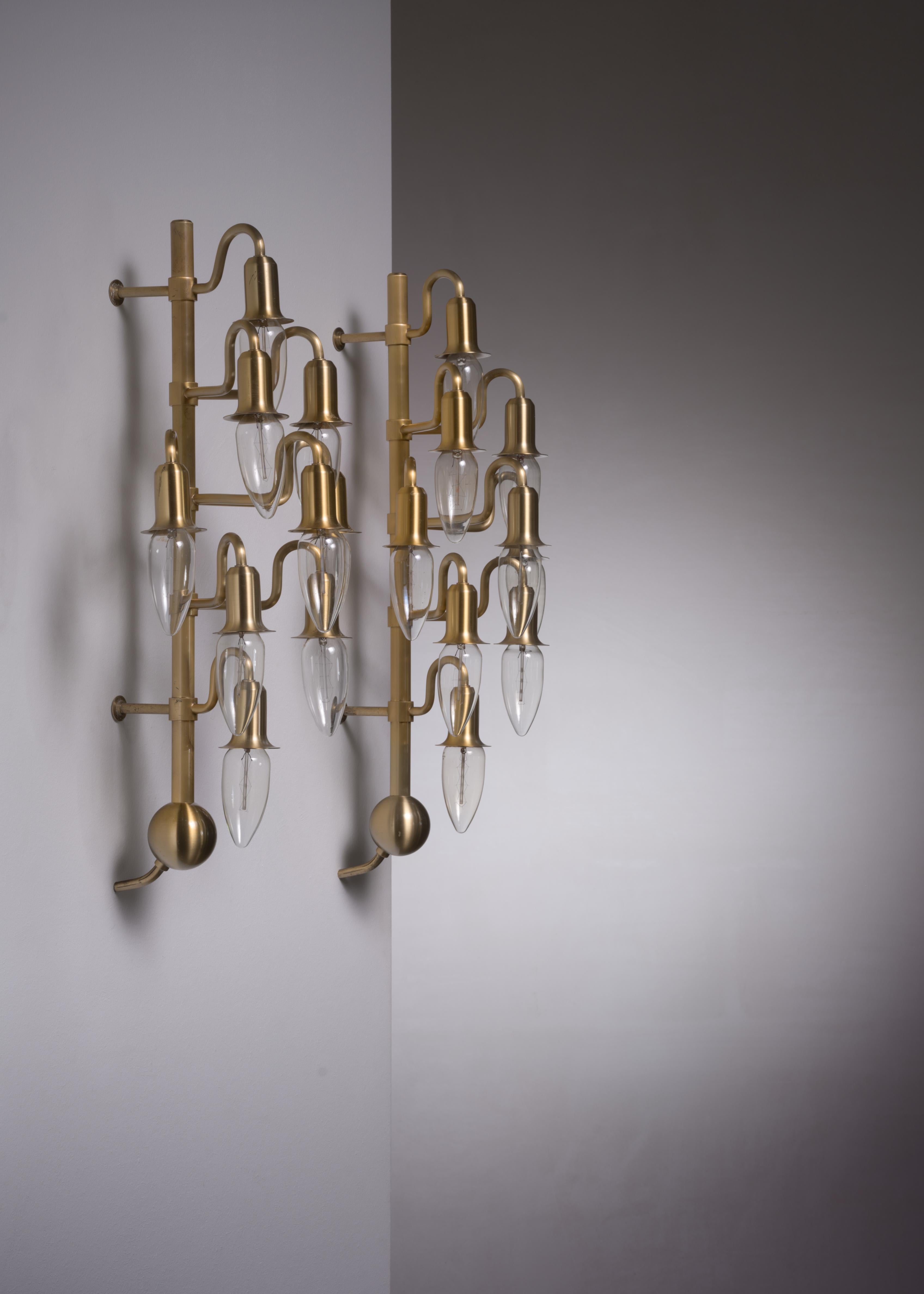 A pair of brass wall lamps with nine arms each.