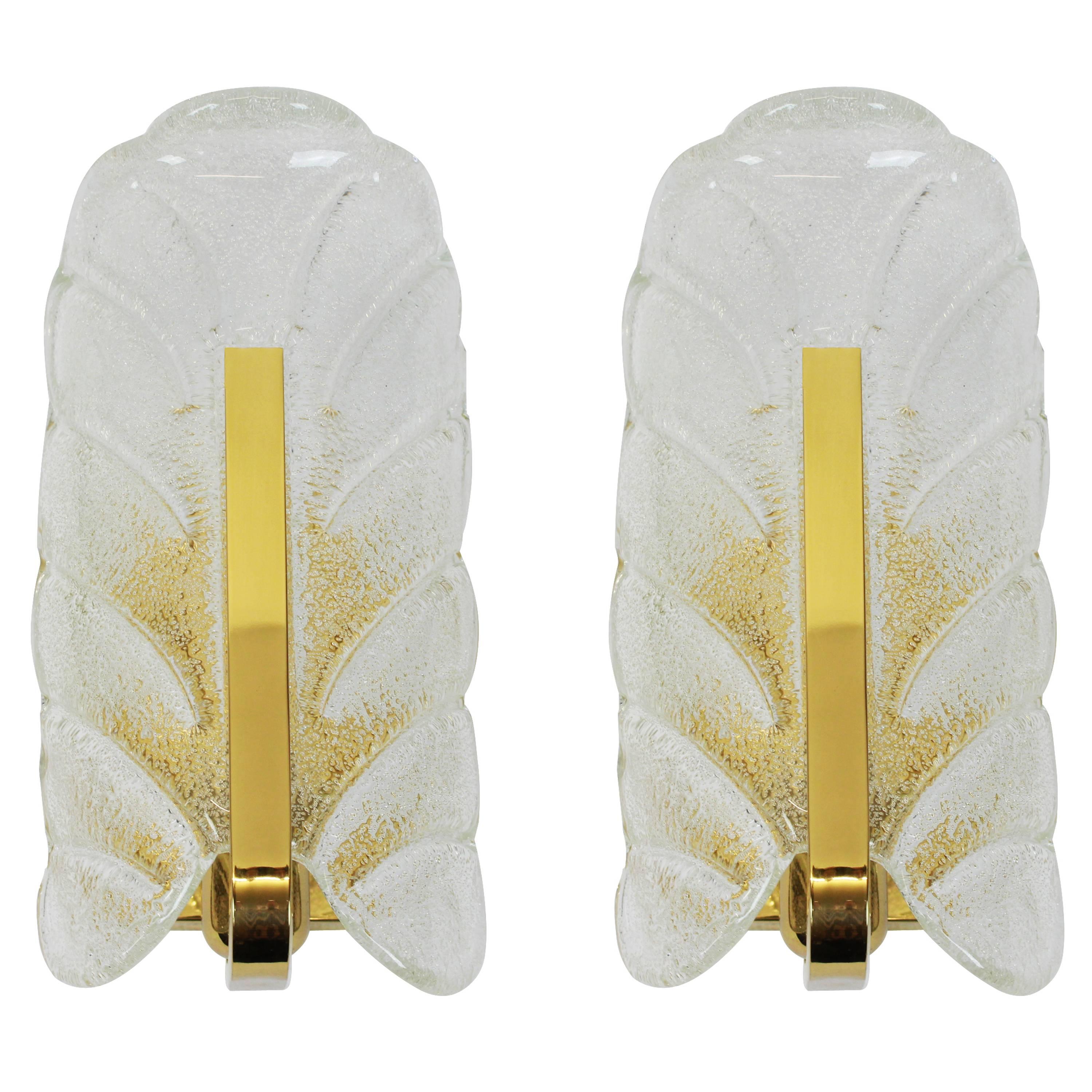 Very glamorous wall sconces designed by Carl Fagerlund for Orrefors glass, manufactured in midcentury, circa 1960-1969. Each sconce features a polished brass frame with one Murano glass leave which has a matte frosted relief on the inside and is