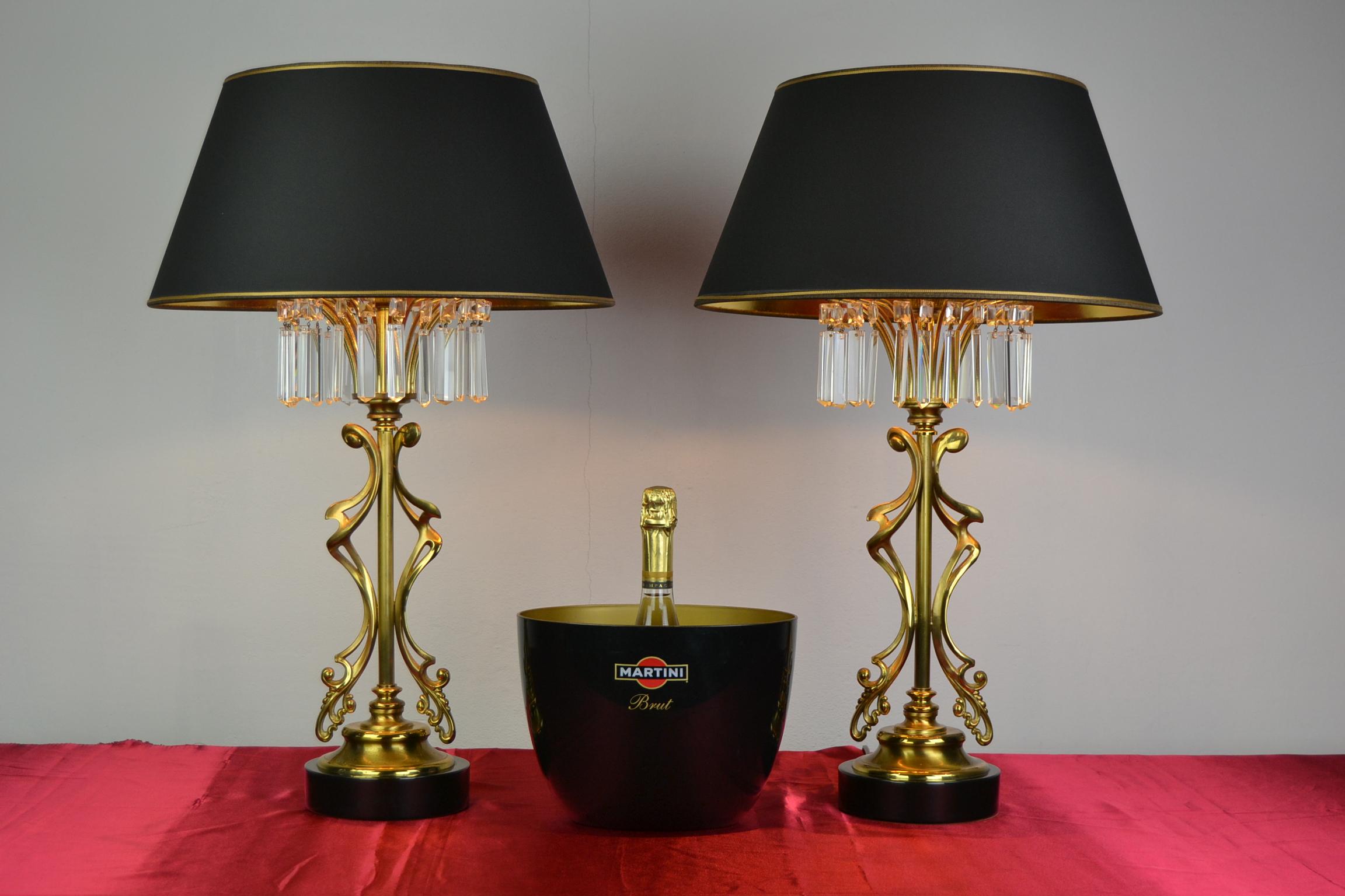 Awesome pair of Lustrerie Deknudt table lamps.
This stylish set of 1970s table lighting have an elegant and even abstract brass base, 
a black foot and on top sparkling crystal paces, which gives the awesome effect 
by the reflection in the