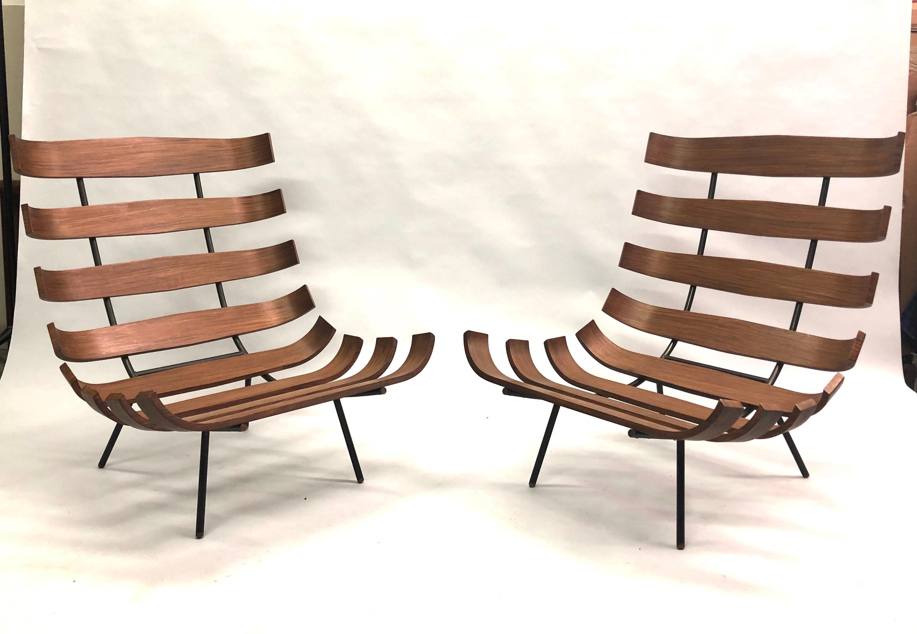 Pair of Brazilian Mid-Century Modern 'Costela' Armchairs / Lounge Chairs by Carlo Hauner and Martin Eisler, circa 1954. 

Black enameled steel frame, tiny brass finial feet and curved Brazilian Rosewood ribbed structure in a subtle, matte patina.
