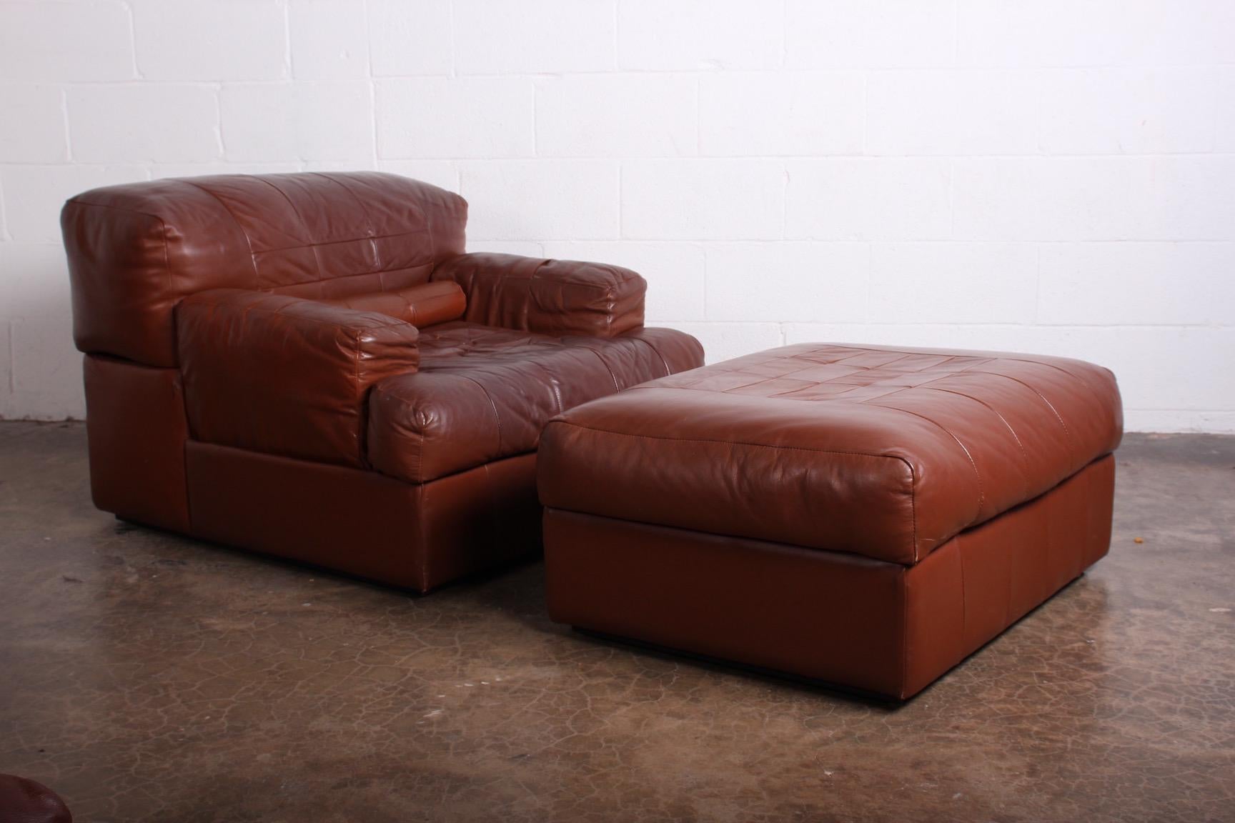 A pair of patinated leather lounge chairs and ottomans designed by Pervical Lafer.