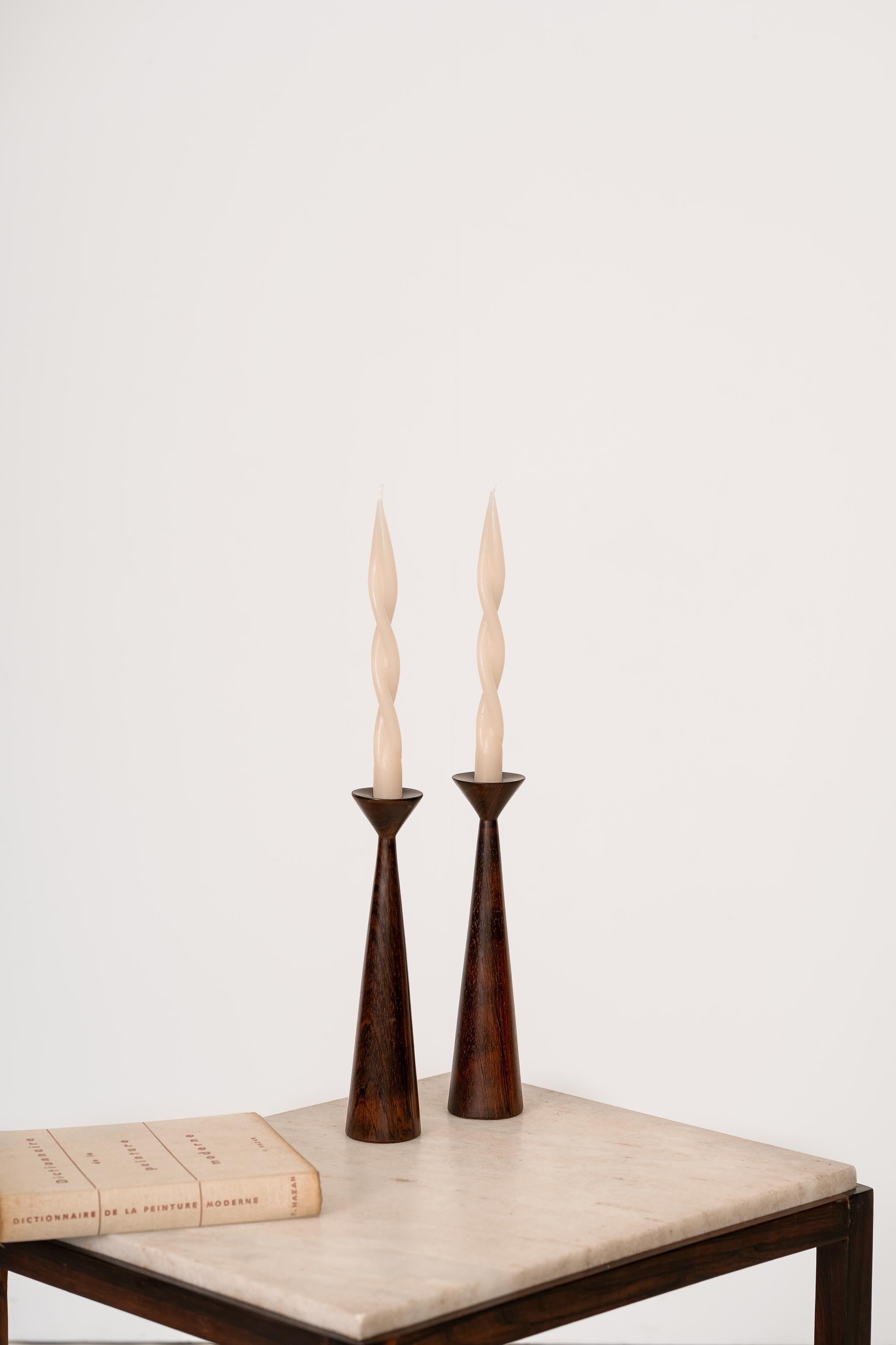 Stunning pair of mid-century candlestick made in solid Brazilian rosewood of unknown authorship. They are the two tallest in the group.