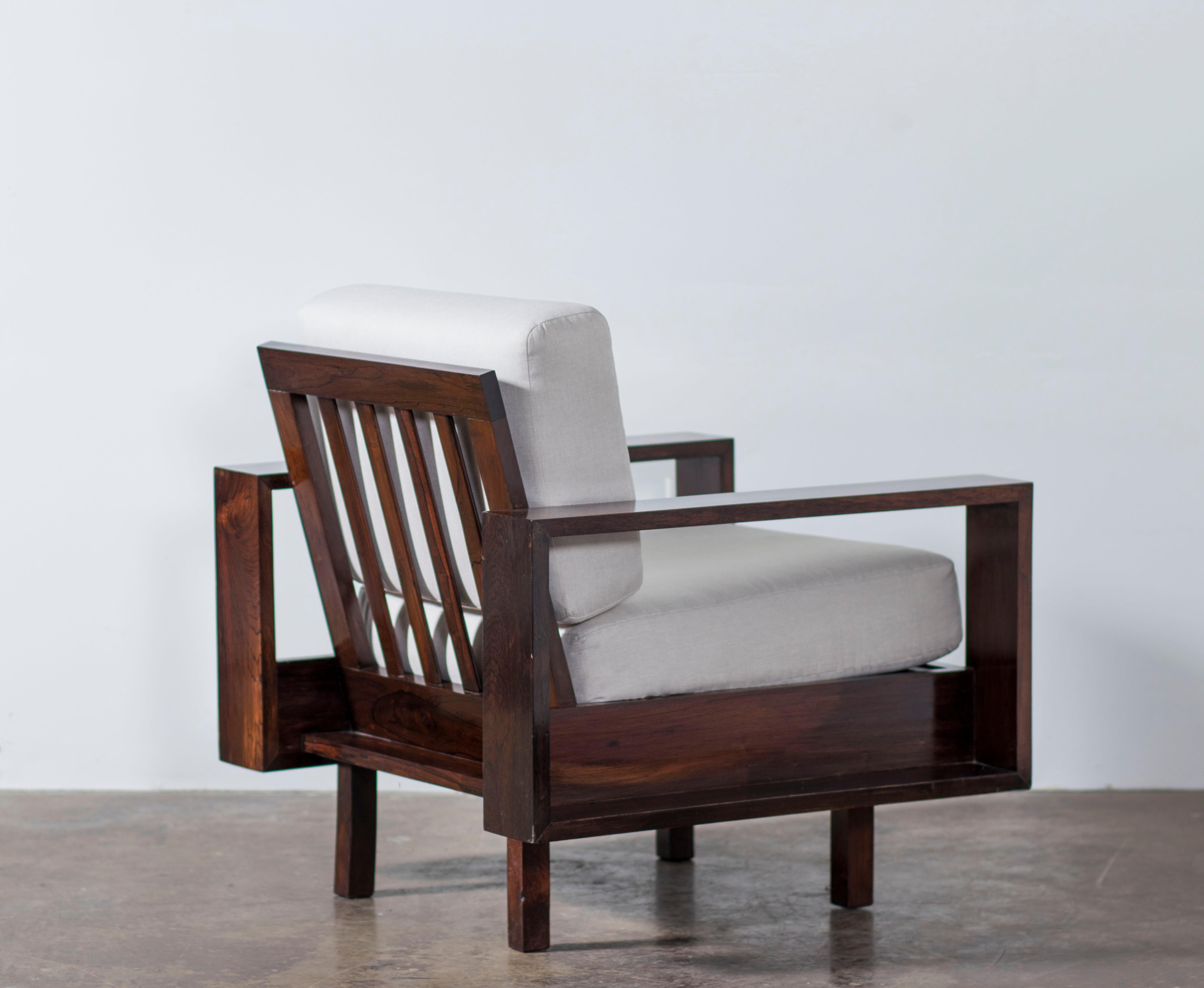 These armchairs are made of solid Brazilian Rosewood (Jacaranda) and recently reupholstered in off white linen by the experienced craftsmen in our team. The armrests have a rectangular design with a back of vertical slats and angular arms.

The