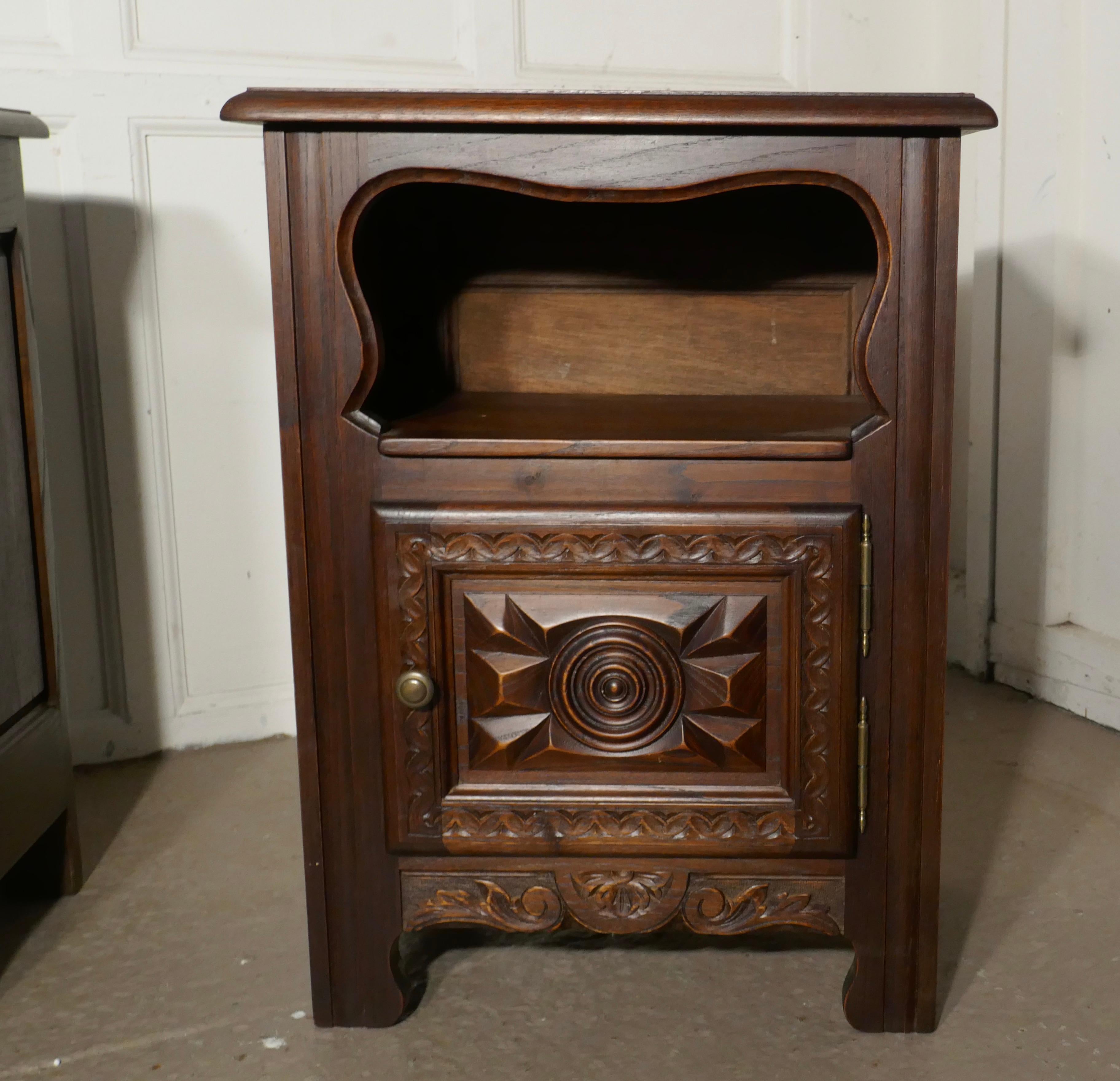 Pair of Breton oak bedside cupboards 

 This is is a chunky pair of Breton style oak bedside cabinets, at the top they have an open bookshelf, and a cupboard below The fronts of the doors have a Breton Wheel of life design 
The cabinets are in