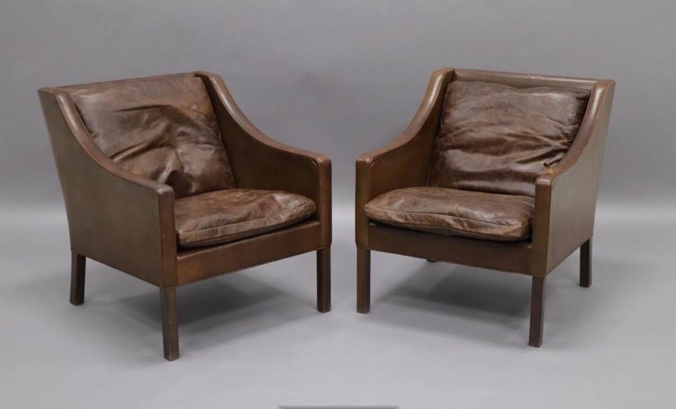 The 2207 Lounge Chair was designed by Borge Mogensen with a distinctively shaped low back. Morgensen designed the 2207 in 1963. This pair is wonderfully patina'd and while there is decent wear and tear, they upholstery will likely withstand another
