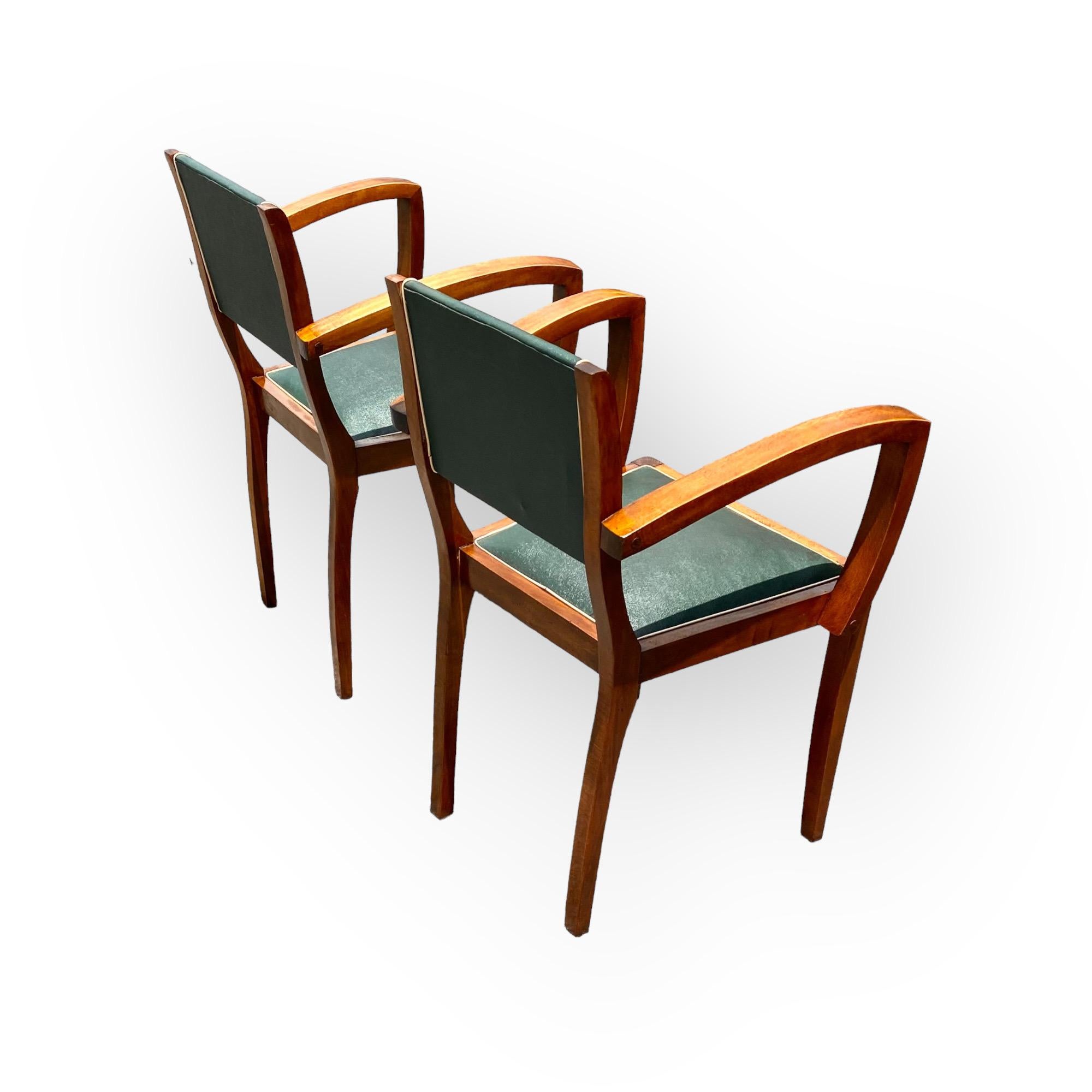 An outstanding pair of French Parisian Art Deco bridge chairs, with open arms having the original faux leather upholstery with contrast banding in good condition, circa 1930.
One must love the classic Art Deco lines of the pair as their