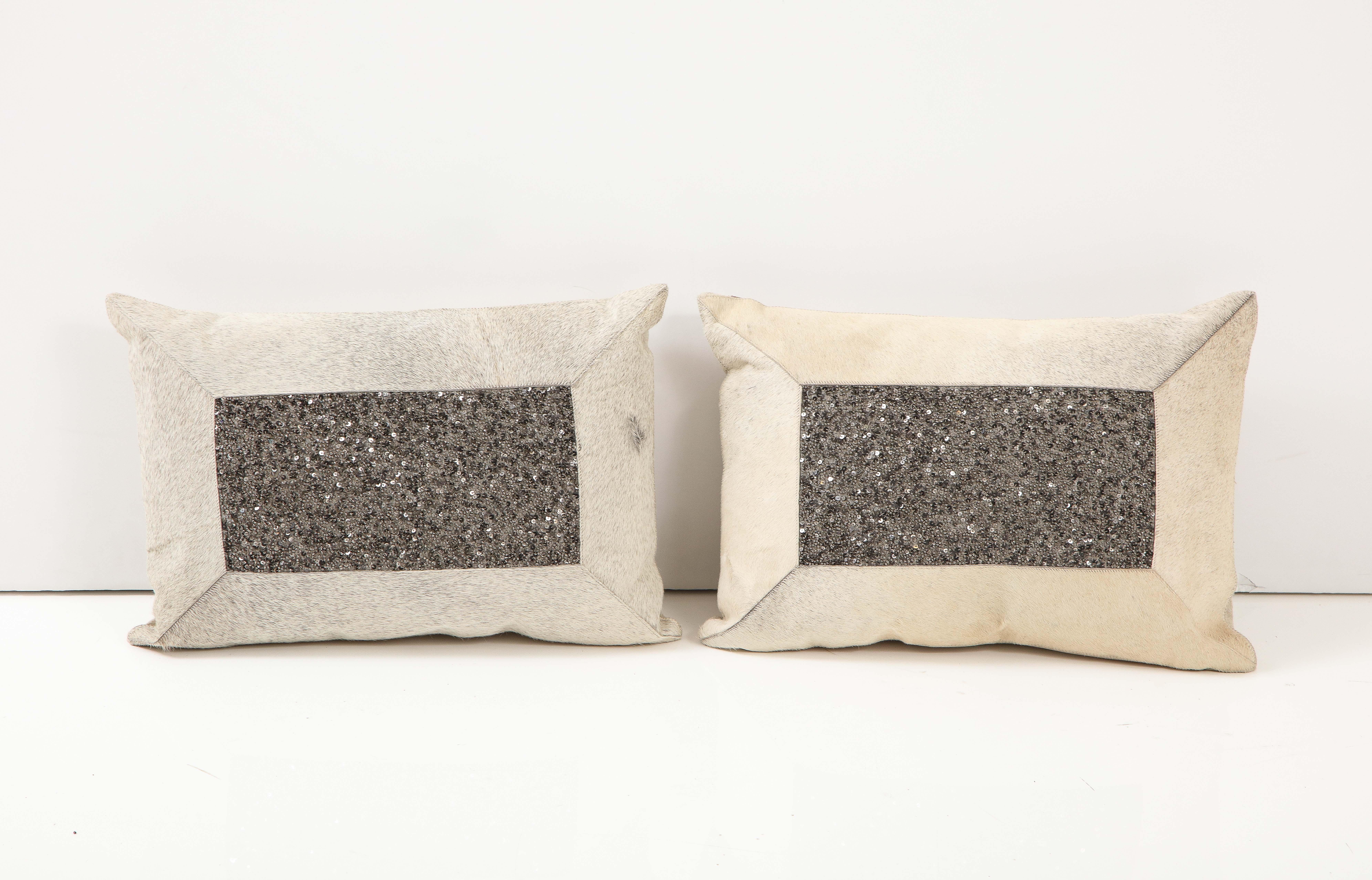 Pair of light grey/beige hide pillows with dark grey bead benters and zippered linen backs. Feather/Down inserts.