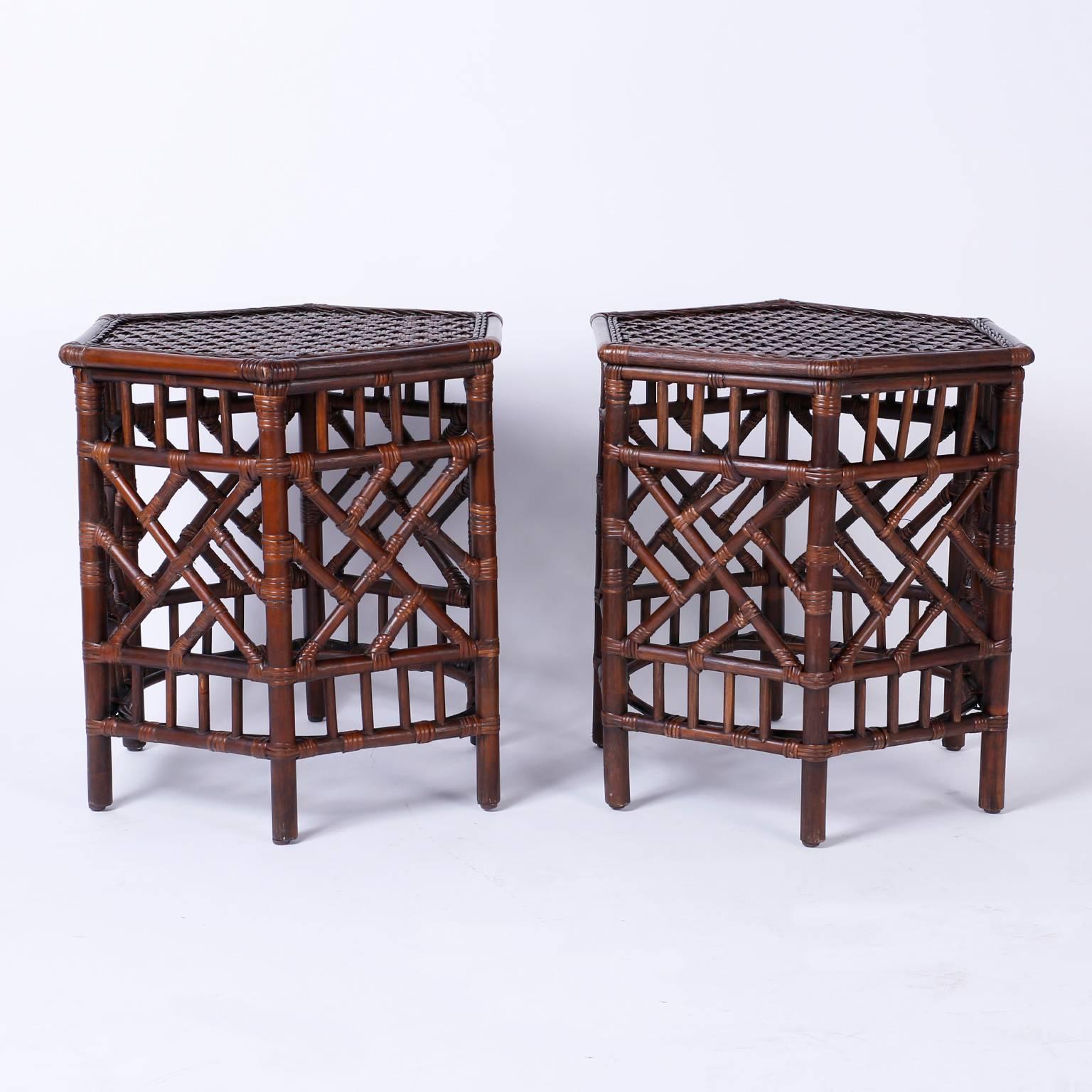 Pair of British Colonial style bamboo, rattan or wicker end tables or stands with woven reed hexagon tops and Chinese Chippendale style panels on all six sides.