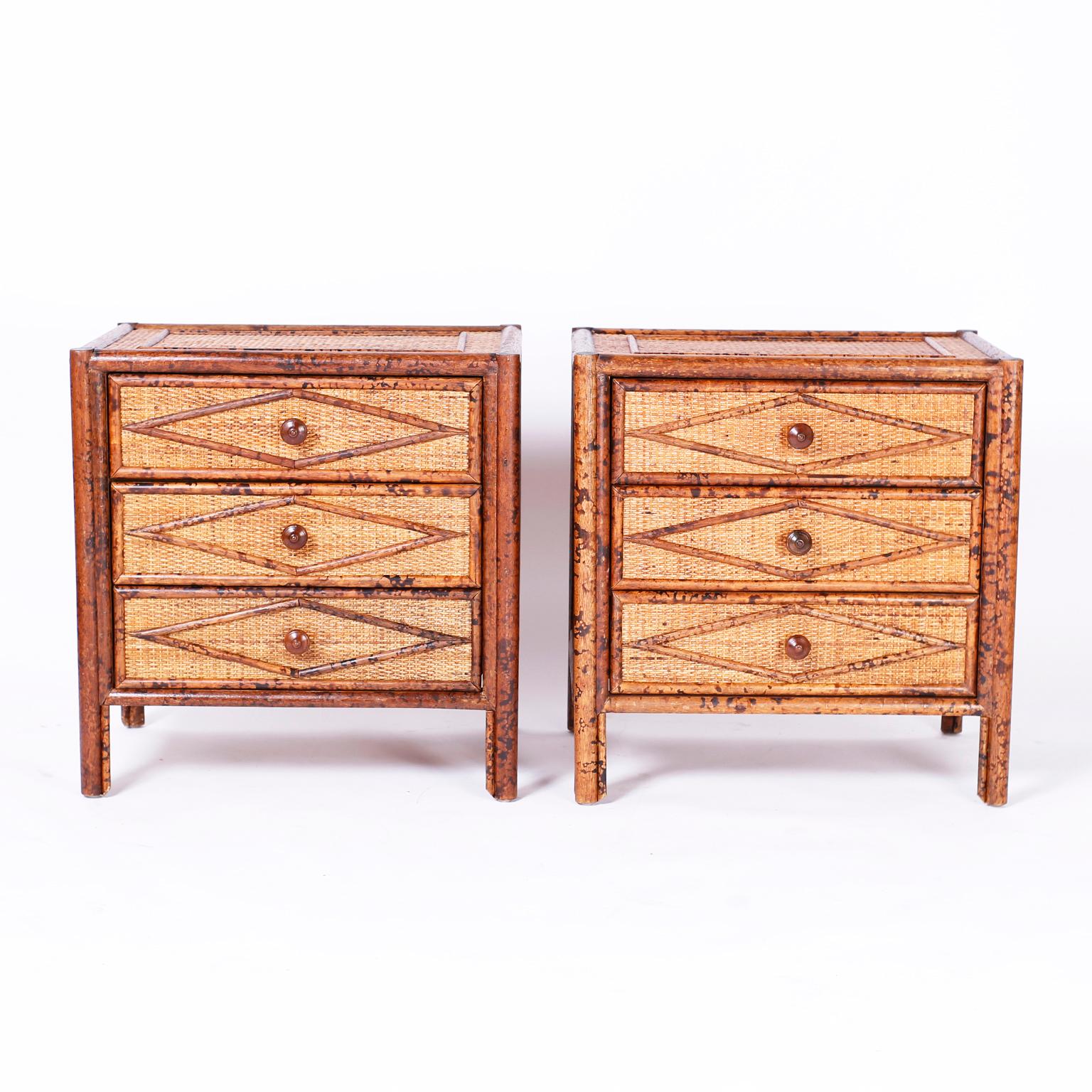 Pair of British Colonial three-drawer stands or chests with faux burnt bamboo frames, grass cloth panels on the tops, sides and front with applied bamboo geometric designs.