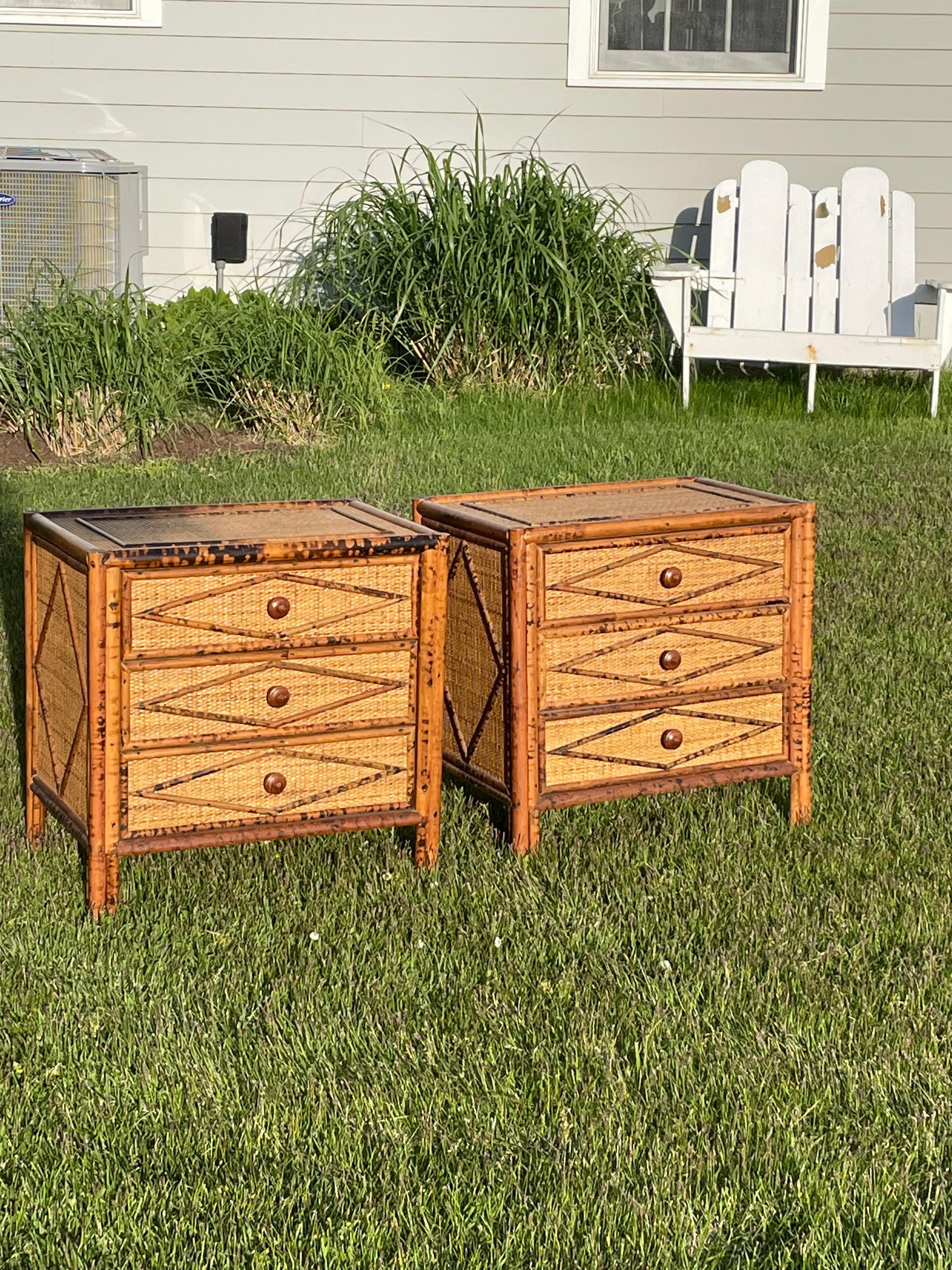 Handsome mid century pair of night stands or end tables. They are very well made of faux burnt bamboo and grass cloth The nightstands have three drawers in each and a geometric pattern on drawer fronts, tops and sides. These are in very good