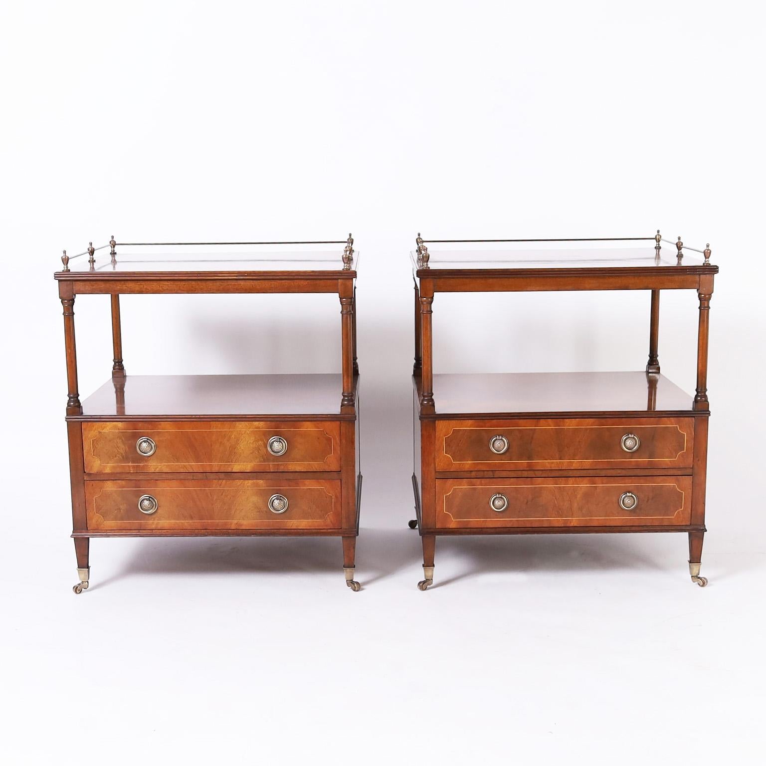 Handsome pair of English stands crafted in mahogany with brass galleries on top supported by classic turned columns over two drawer cases on tapered legs with brass casters. Tagged in a drawer Ipswich England.