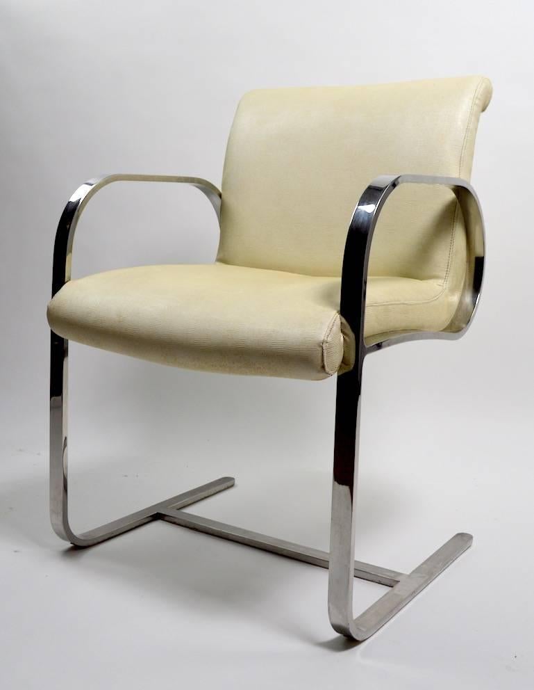 Pair of stylish armchairs attributed to Brueton, flat bar chrome frames support vinyl seats. Overall good condition, chrome shows cosmetic wear, specifically light scratching to the arm surface, no rust, or pitting, vinyl upholstery shows wear, as