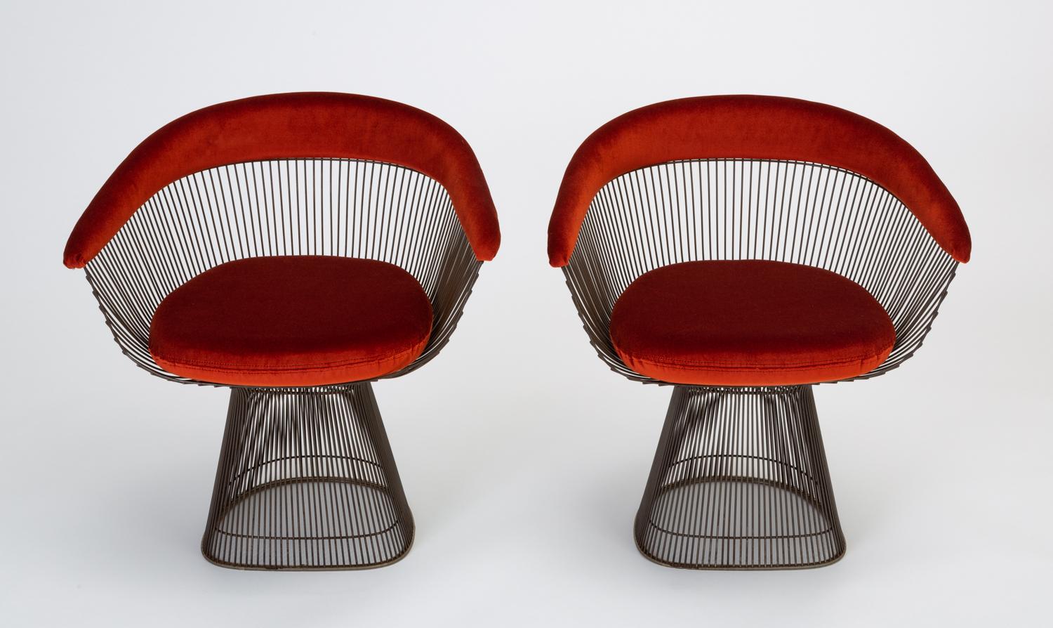 A pair of intricately minimal armchairs by Warren Platner for Knoll. Designed in 1966, the Platner collection featured designs defined by curved and welded steel spokes. The chairs have an hourglass shape with seat and curved back cushions in a