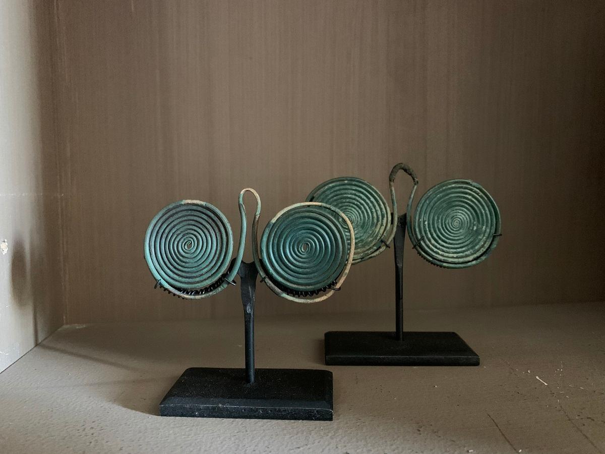 Pair of Spiral pendants, bronze age, Europe, circa 1000 BC, 3 and 3 half inches 7 9 cm, mounted on custom stands.

Provenance: From a private European collection; formed in the 1980s.