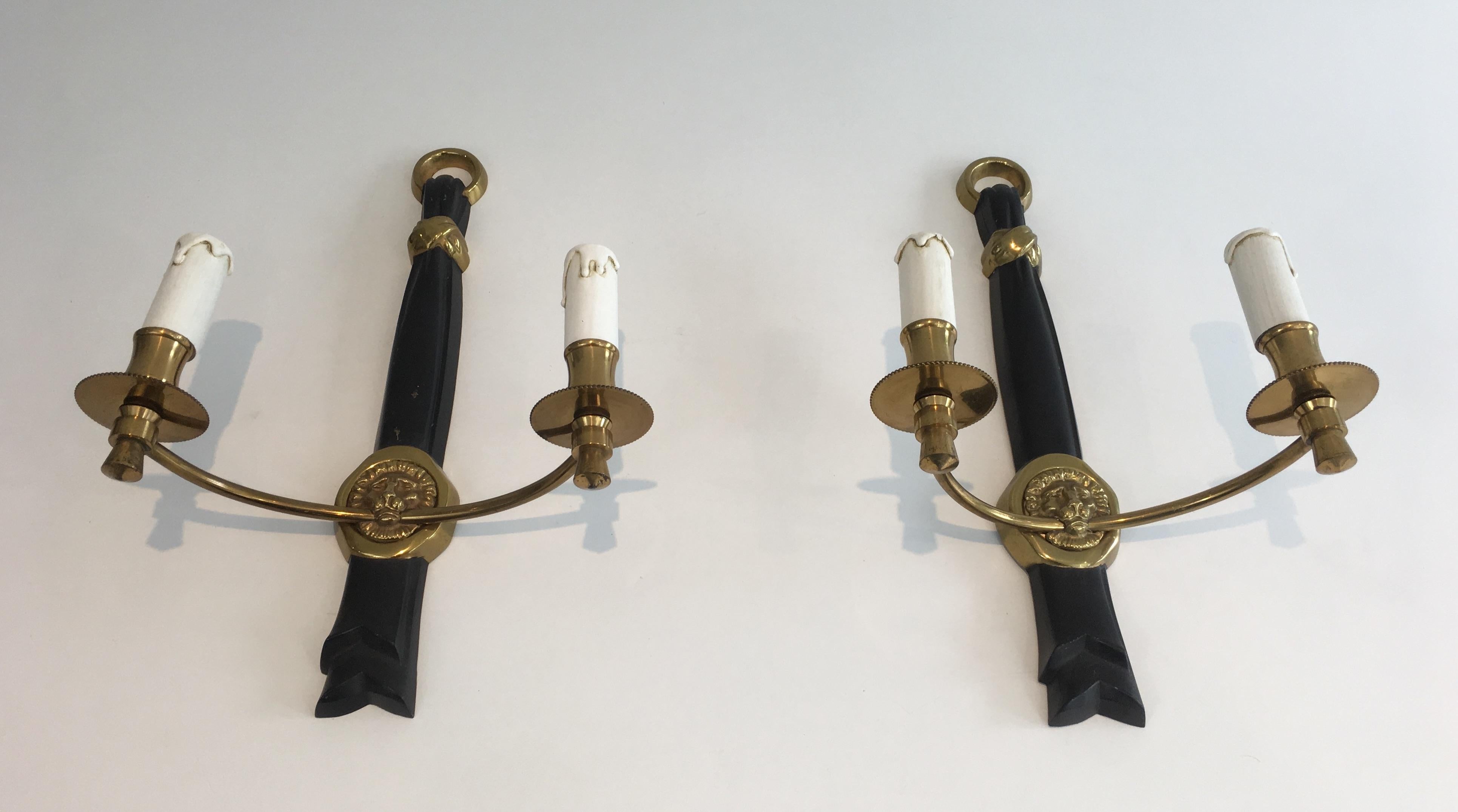 This pair of neoclassical wall sconces is made of bronze and black lacquered bronze with lion heads. This is a French work, circa 1970.