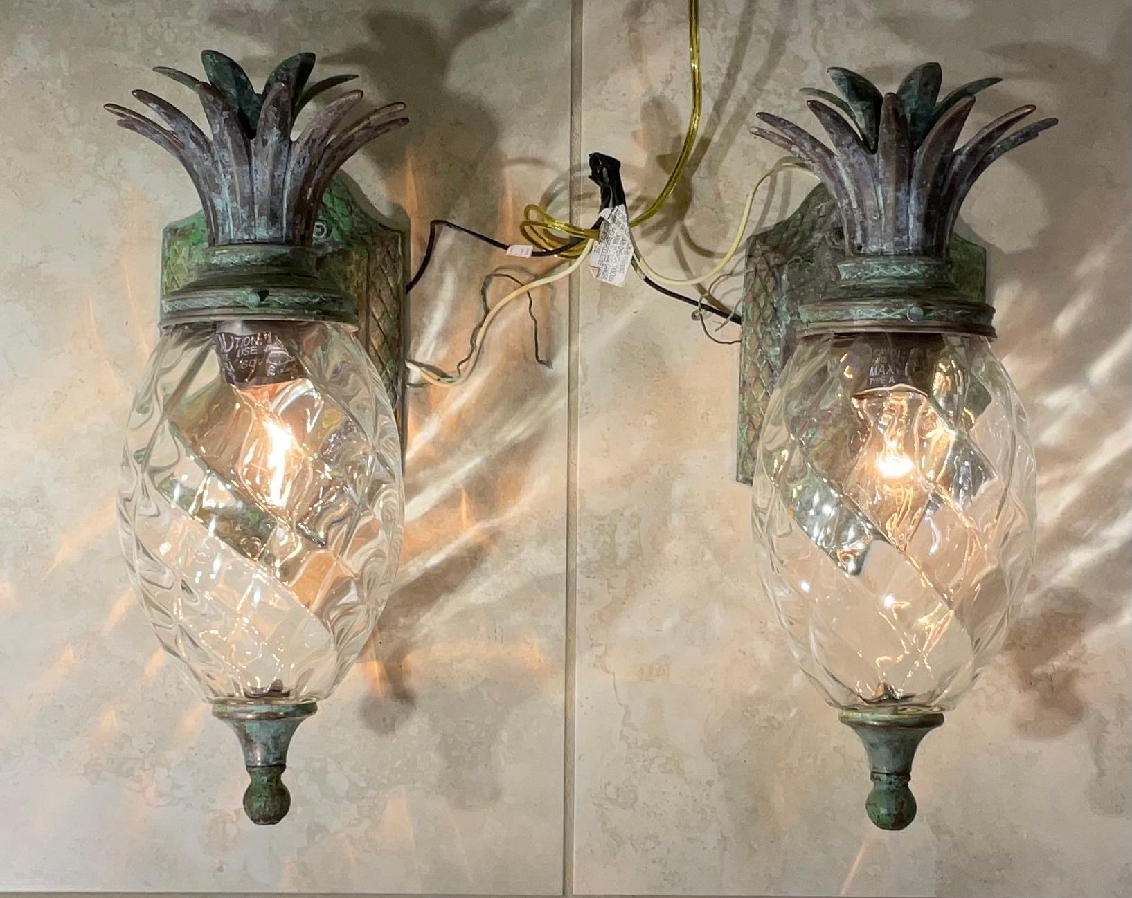These stunning wall sconces feature a unique pineapple style design, crafted from a combination of brass, bronze, and metal with decorative glass. The intricate details and rich patina create a truly elegant and eye-catching piece. One 60/watt light