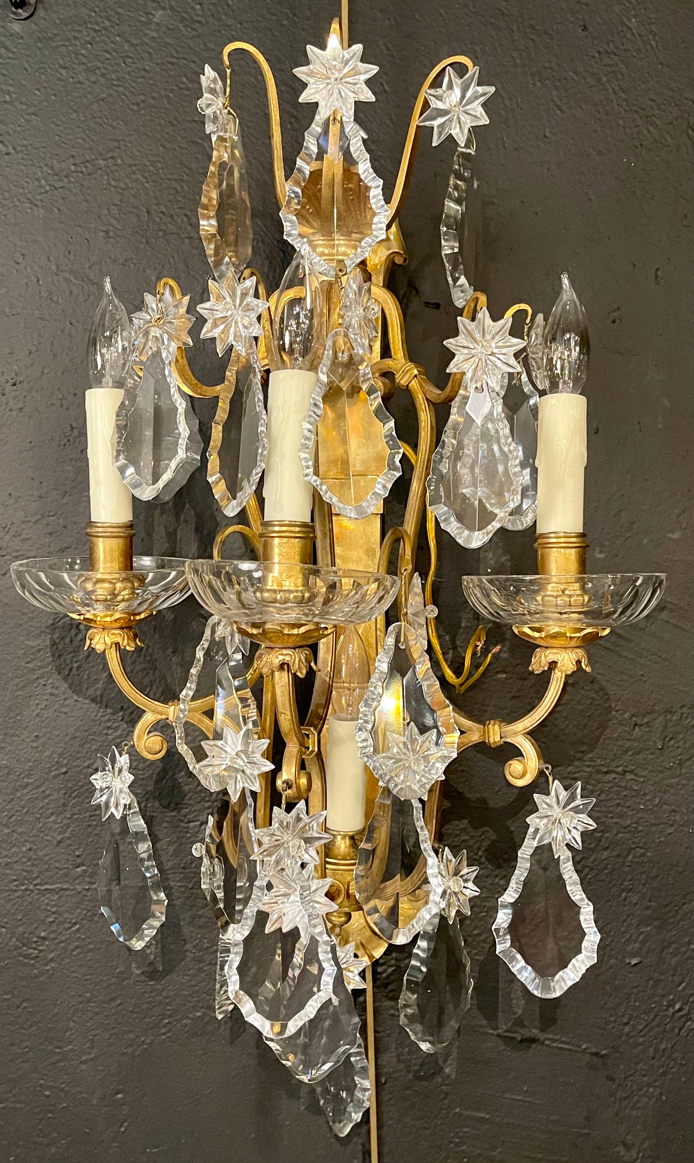 Pair of bronze and crystal wall sconces or lights. 3-light are wired onto this finely framed pair of solid bronze and finely cut crystal wall sconces. Pair of heavy bronze shell and floral designed back plates with large crystals and floral crystals