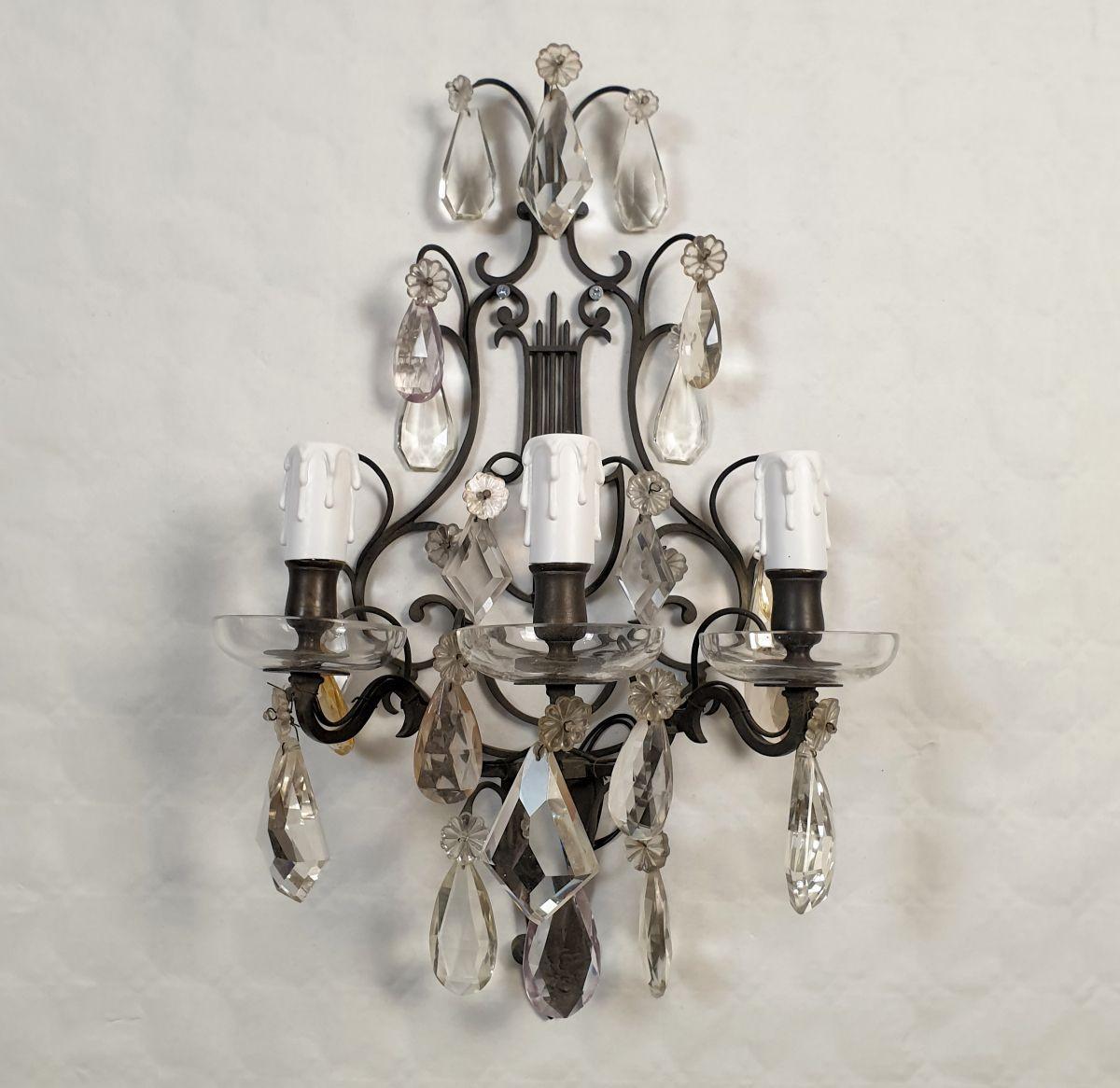 Pair of crystals wall sconces, France circa 1900s.
The French sconces have a bronze frame with a Lyre shape.
The antique sconces are fully ornate with crystals: a few of them in pastel soft colors.
Each sconce has 3 lights and is rewired.
Very good