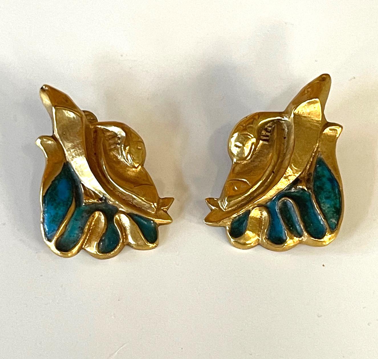 A pair of bespoken earrings by French Art Jeweler Line Vautrin (1913-1997). The cast bronze earring features a sculptural design that evokes an archaic form with shell like scroll and wing-like spread decorated with a turquoise enamel surface. They