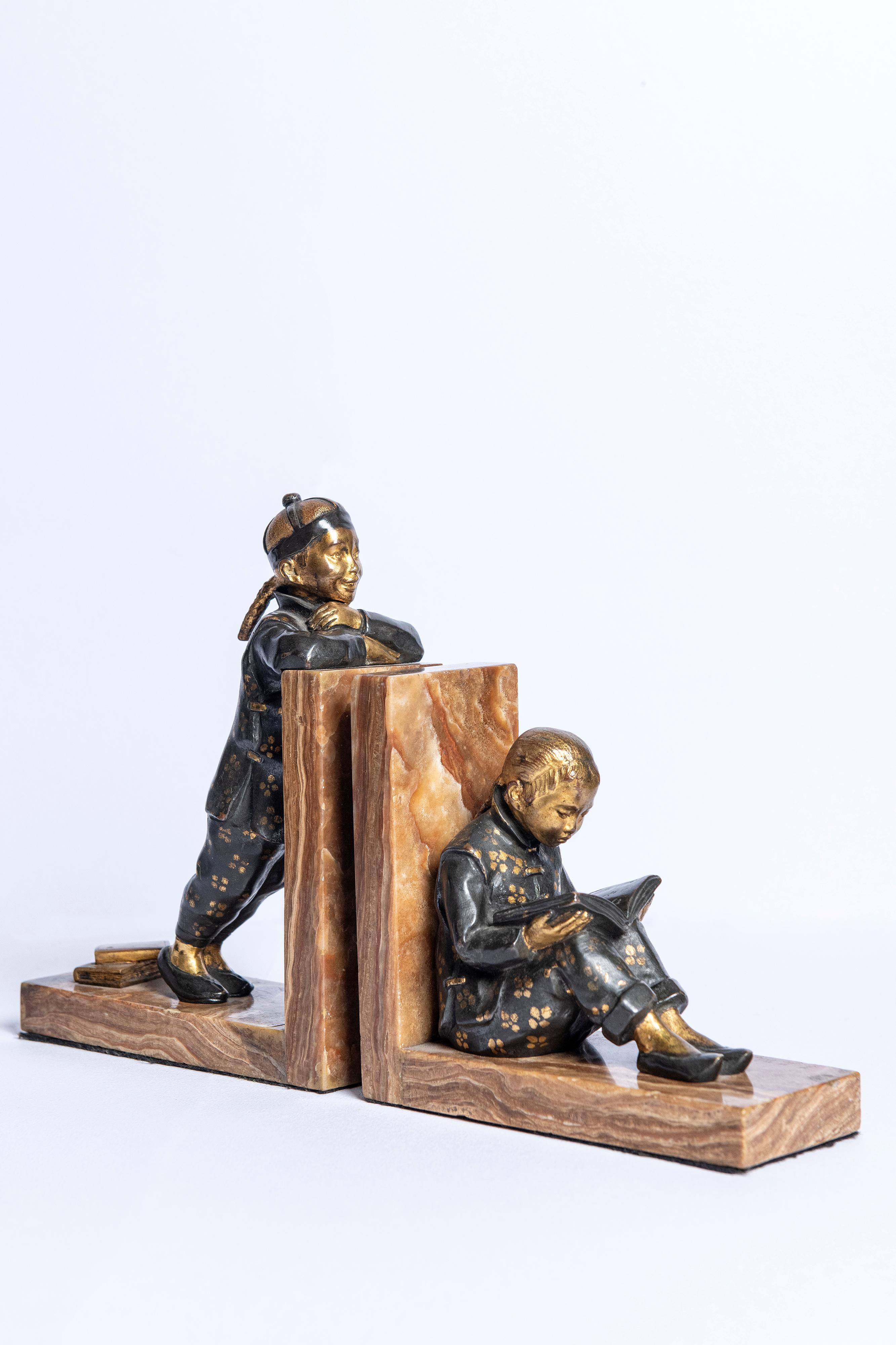 Pair of bronze and marble bookends, signed H.M. White. England, circa 1920.
With Chinese children studying.
     