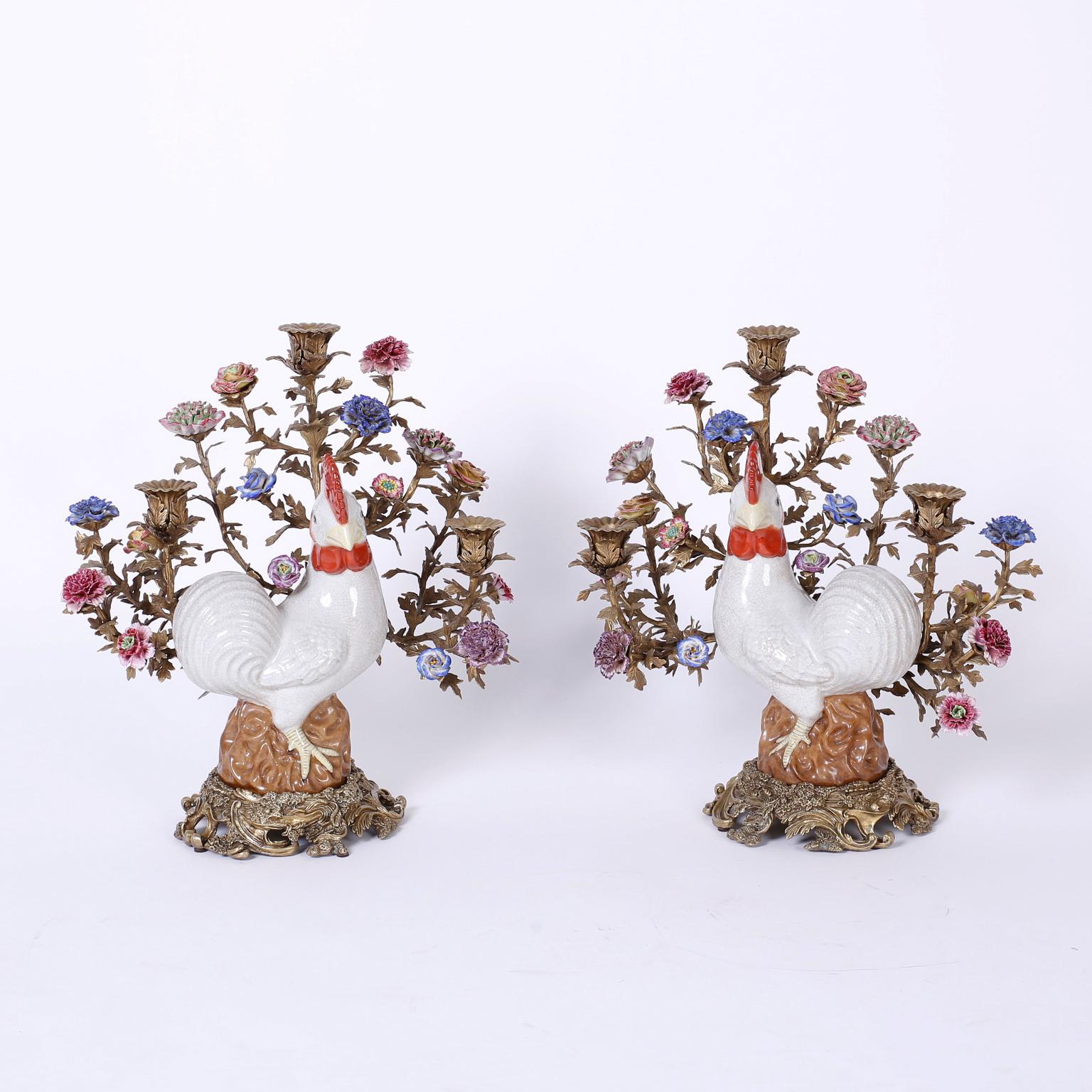 Fanciful pair of three-light candelabra featuring porcelain chickens with an amusing continuance, bronze arms in the form of branches with candle cups and delicate porcelain flowers and floral cast bronze bases.