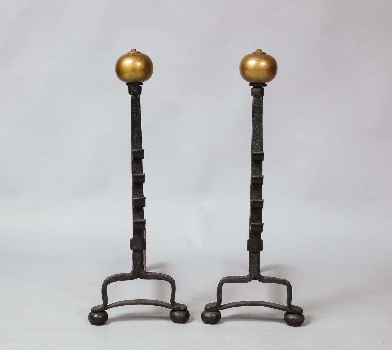 Good pair of 19th century bronze and wrought iron andirons, the suppressed ball tops with nipple finials, over square shafts each with four scrolled elements, the bases with arched legs joined by cross stretchers and standing on flattened ball feet.