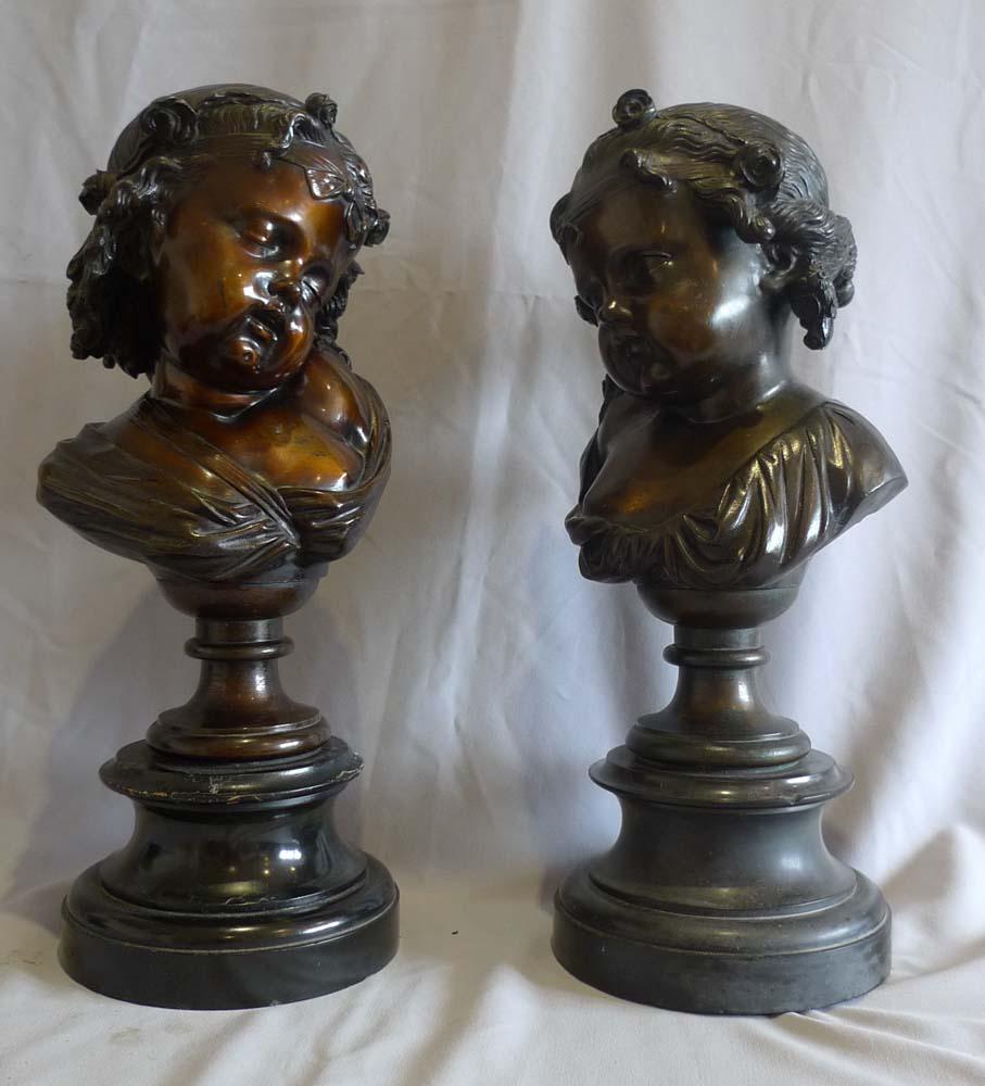 A good pair of patinated bronze busts of two children, set on black marble bases. 