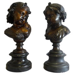  Pair of bronze busts of childs' heads on marble bases.