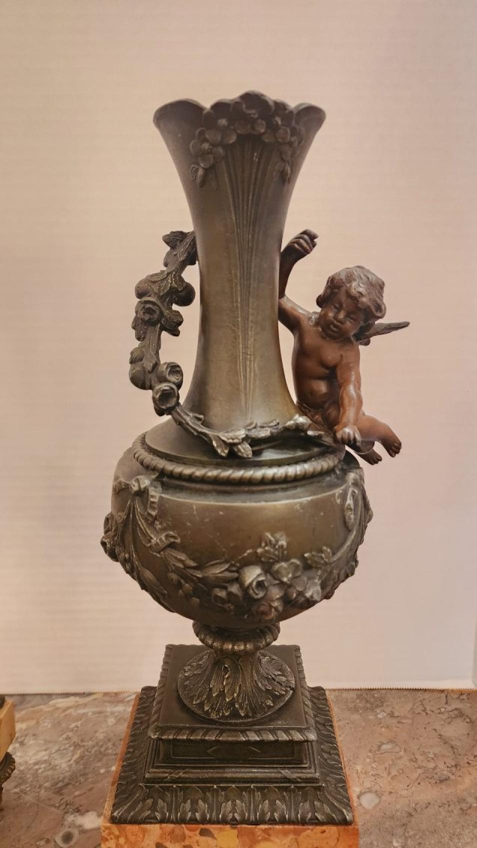 Questa inserzione presenta una coppia di vasi ornamentali a forma di cherubino in bronzo patinato con decorazioni in stile Art Nouveau. Il vaso è realizzato in bronzo con una base in marmo, che sarebbe splendido su un caminetto o sui tavolini con