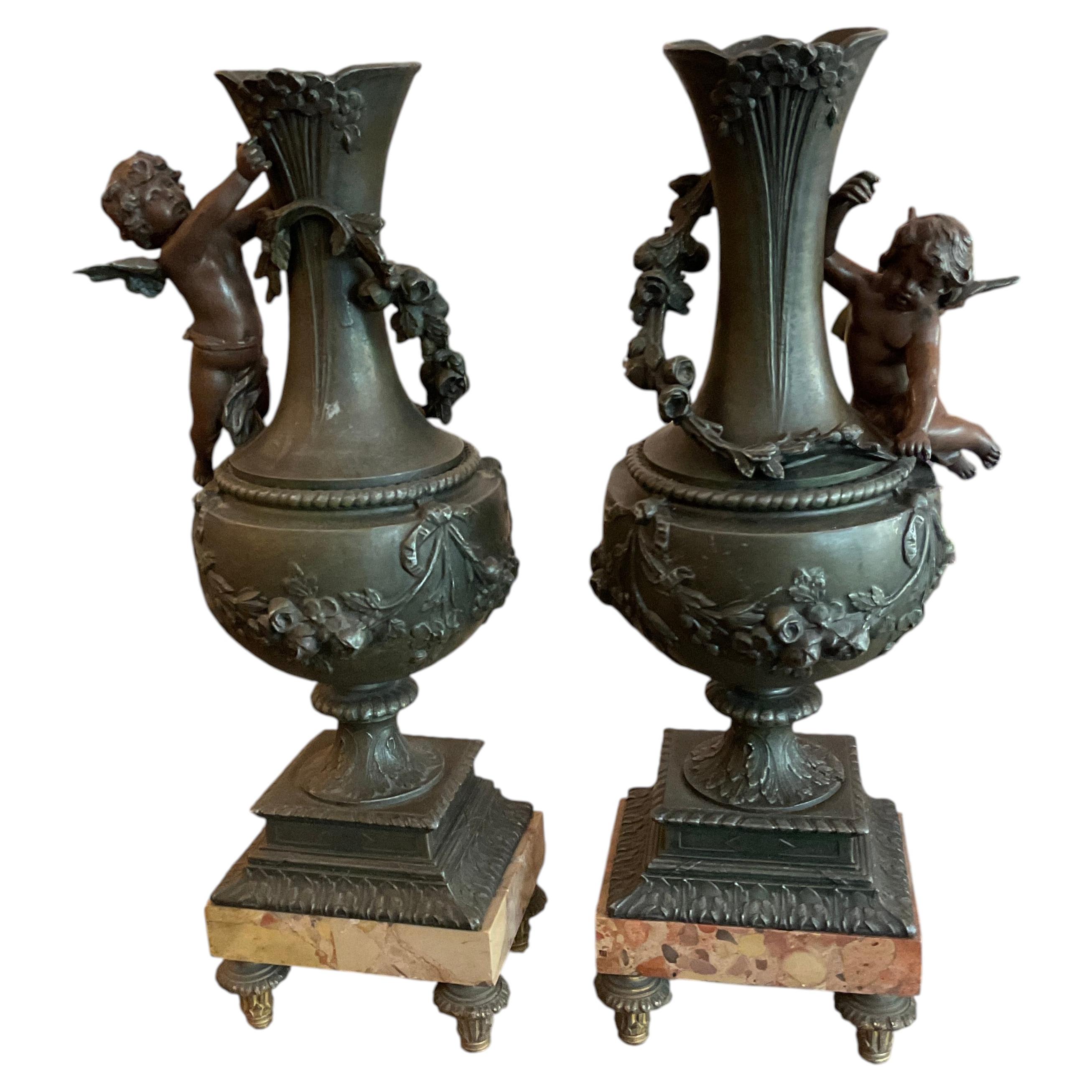 Pareja de jarrones ornamentales de bronce con querubines en venta