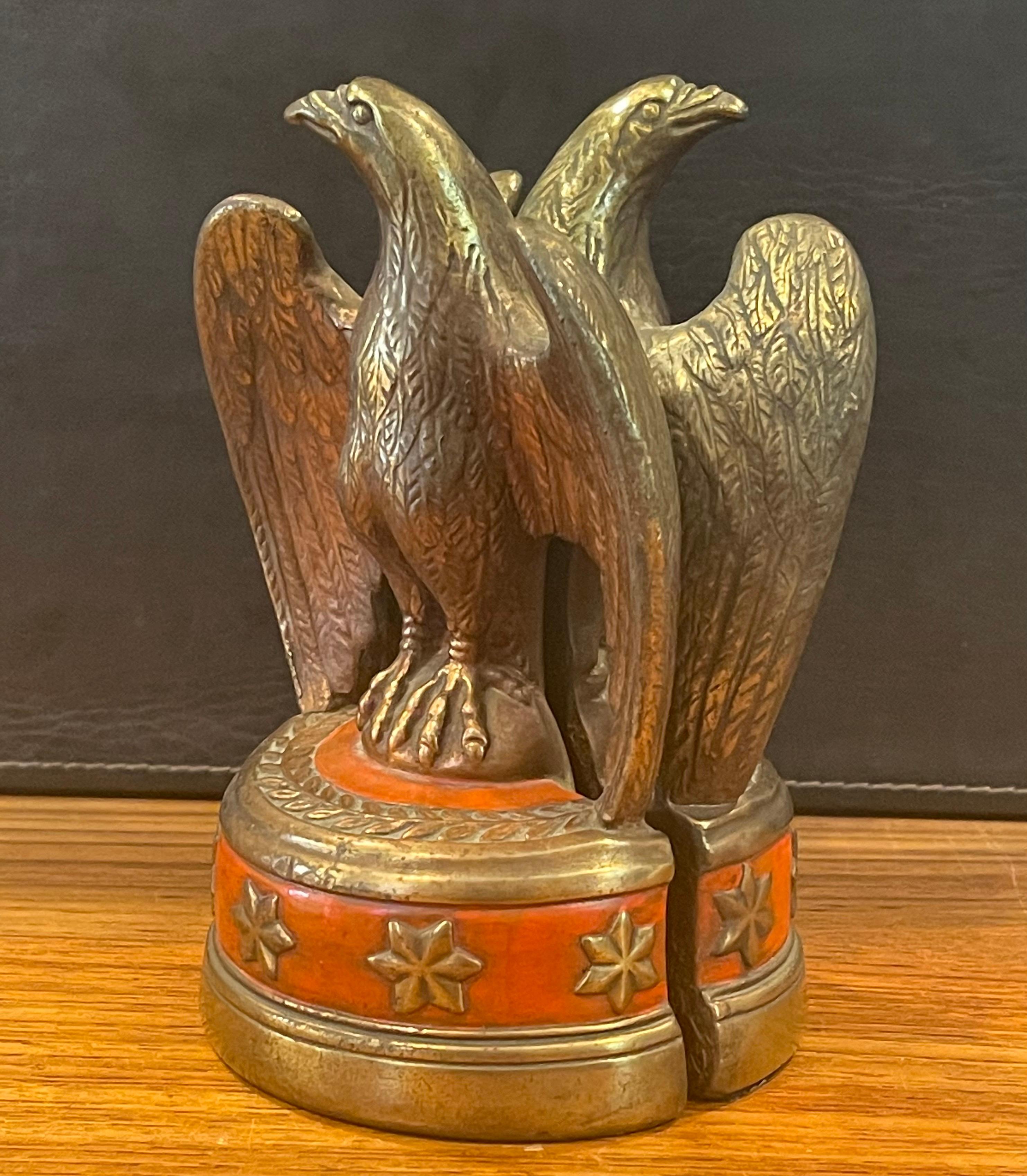 A striking pair of bronze clad American eagle bookends by Marion Bronze, circa 1940s. The eagles rest on a six star semi circle base with a red overlay and are in very good vintage condition. They measure 5.25