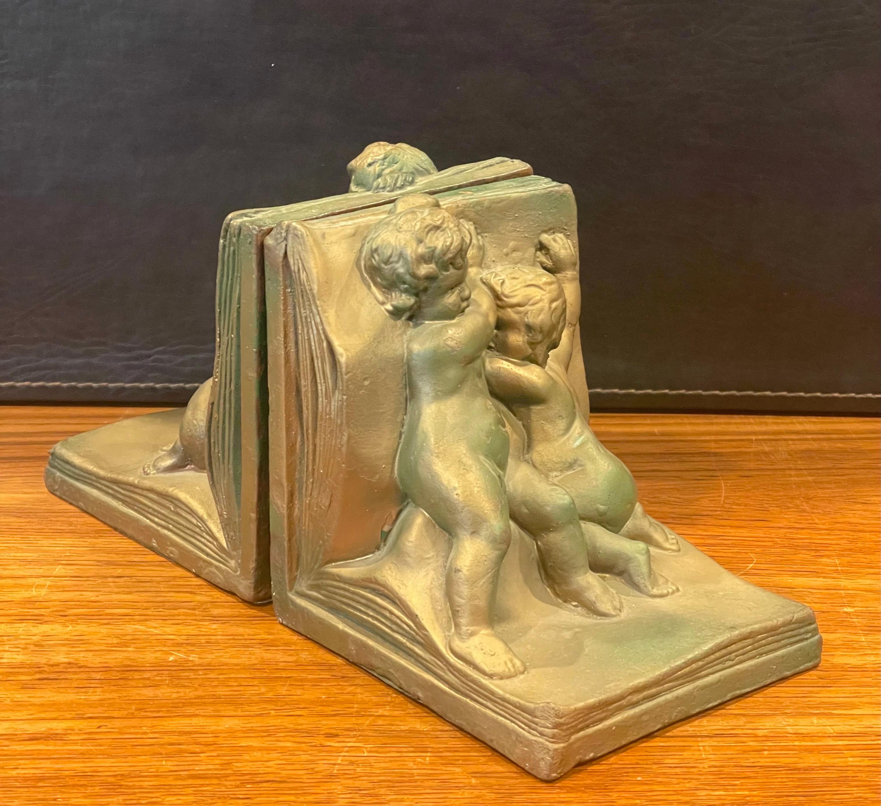 Gorgeous pair of bronze clad cherub Art Deco bookends by Art Bronze, circa 1930s. They are in original condition with a fine patina, some light oxidation and some surface scratches; the pair measures 10.25