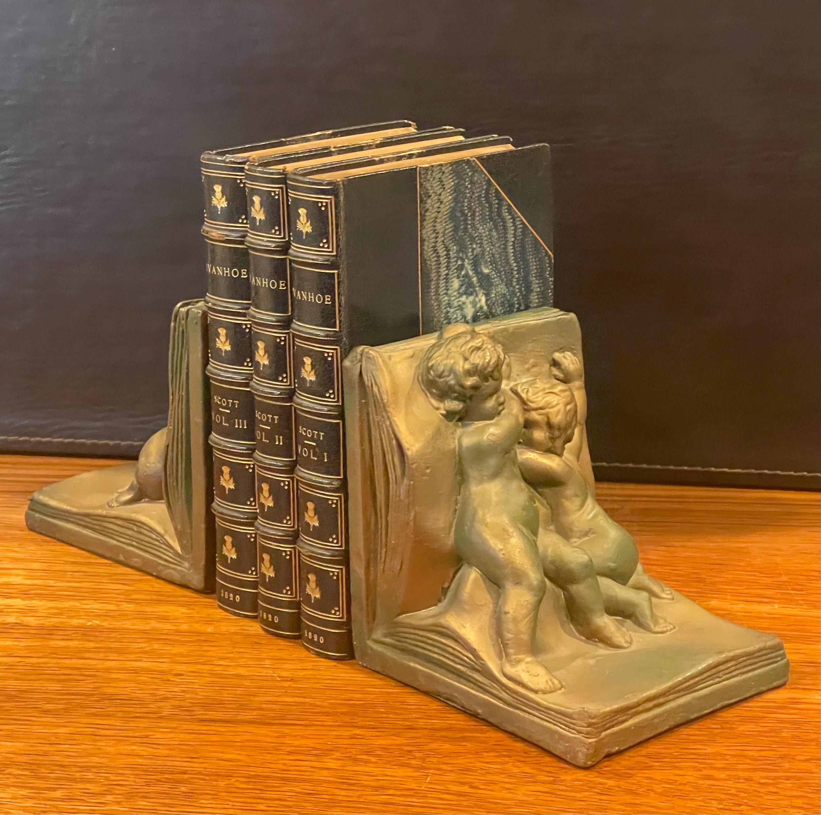 Art déco Paire de serre-livres Art Déco en forme de chérubin recouverts de bronze par Art Bronze en vente
