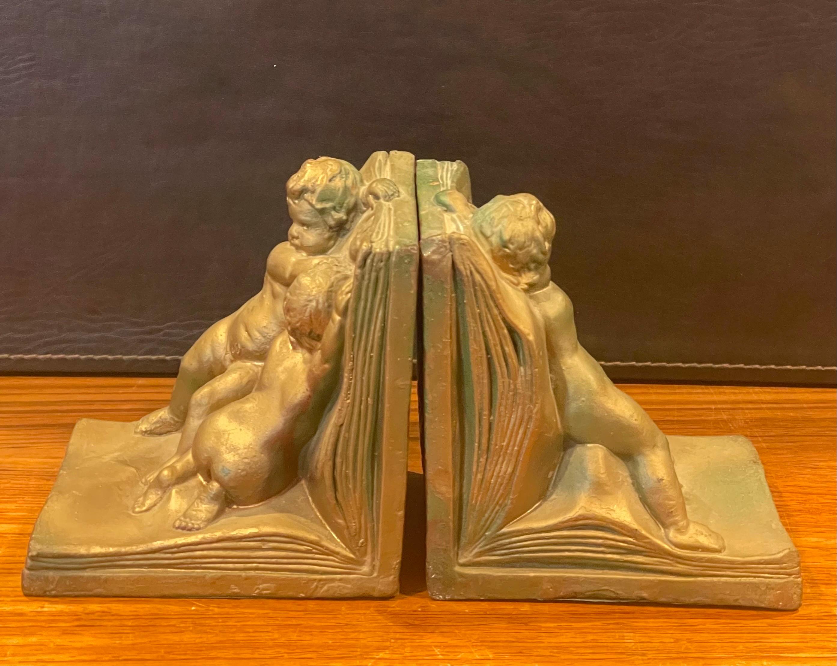 20ième siècle Paire de serre-livres Art Déco en forme de chérubin recouverts de bronze par Art Bronze en vente