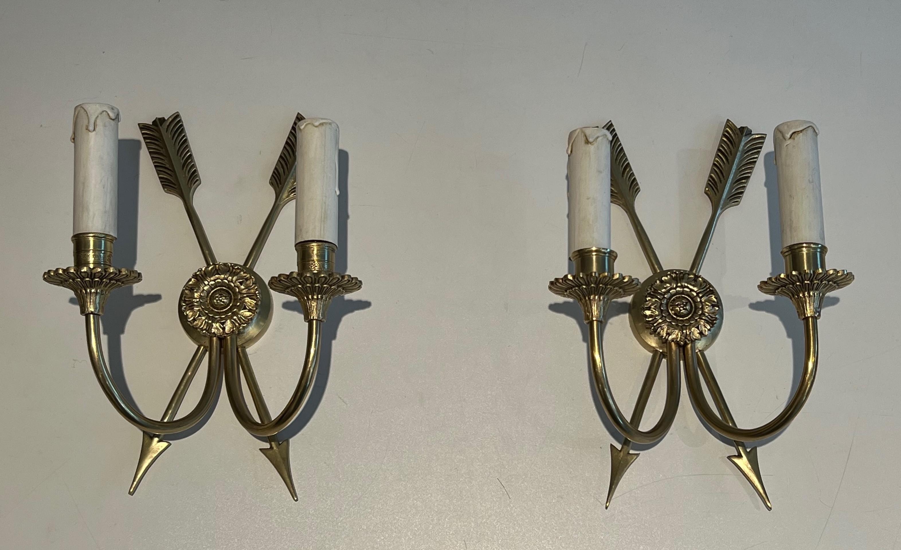 Questa bella coppia di applique in bronzo presenta un macarron cesellato con due frecce incrociate. Si tratta di un'opera francese in stile Impero. Circa 1950