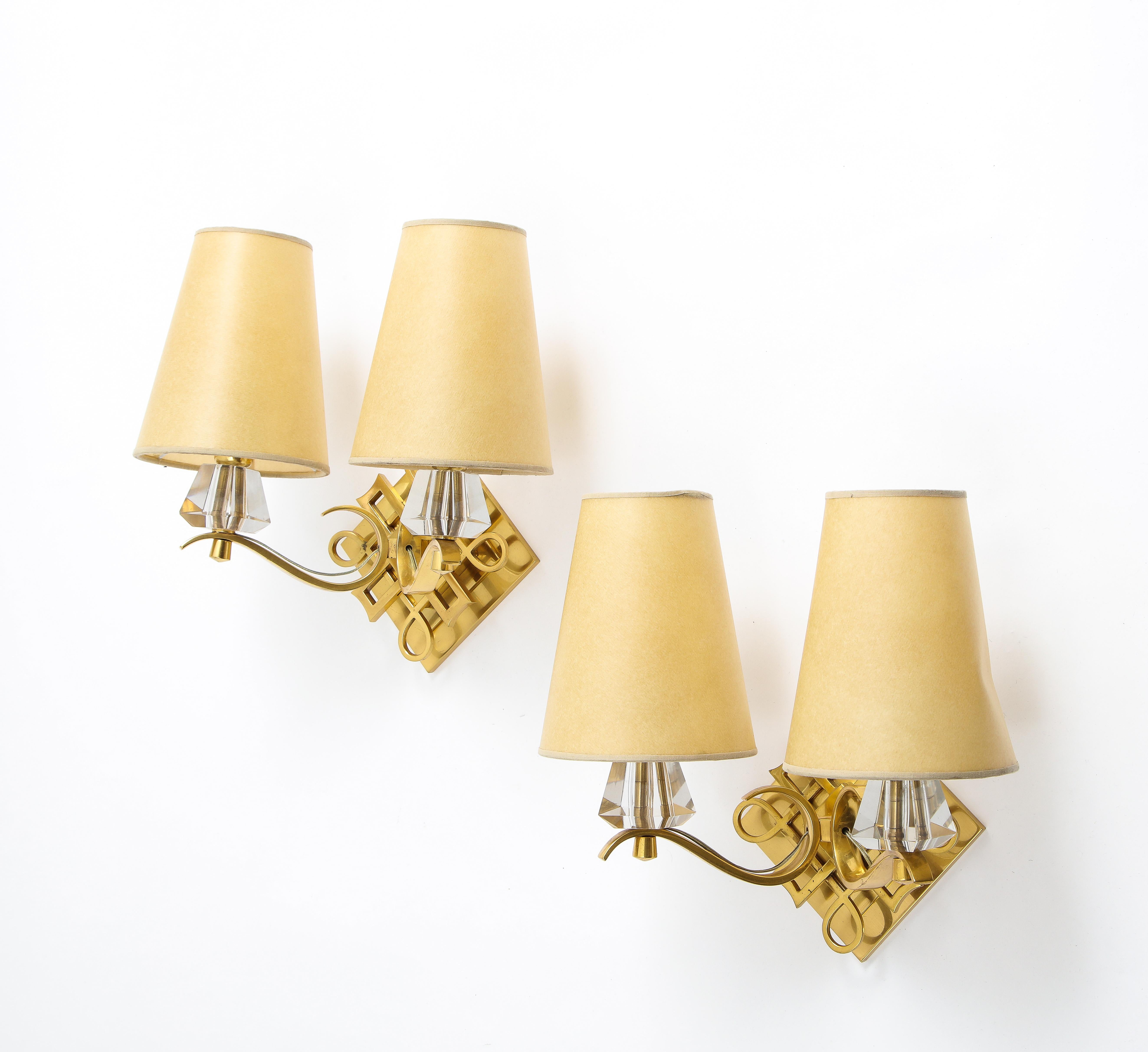 Pair of gilt bronze sconces by Jules Leleu, crystal elements with cast bronze decorative plate. Rewired and supplied with matched custom backplate visible in the picture.
*Lampshades aren't included but are available on request.