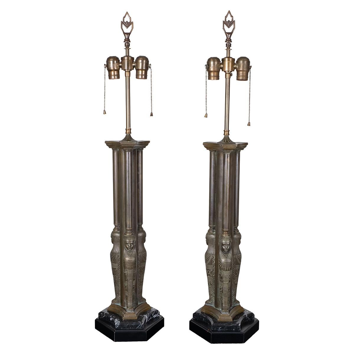 Pair of bronze table lamps depicting Egyptian figureheads on wood and marble bases.
