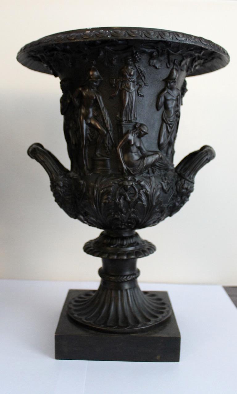 Paire d'urnes classiques en bronze de style Empire, vers 1820, sur des bases carrées avec des poignées doubles sur chacune d'elles. Sujet classique grec autour du corps avec un large rebord superbement conçu.