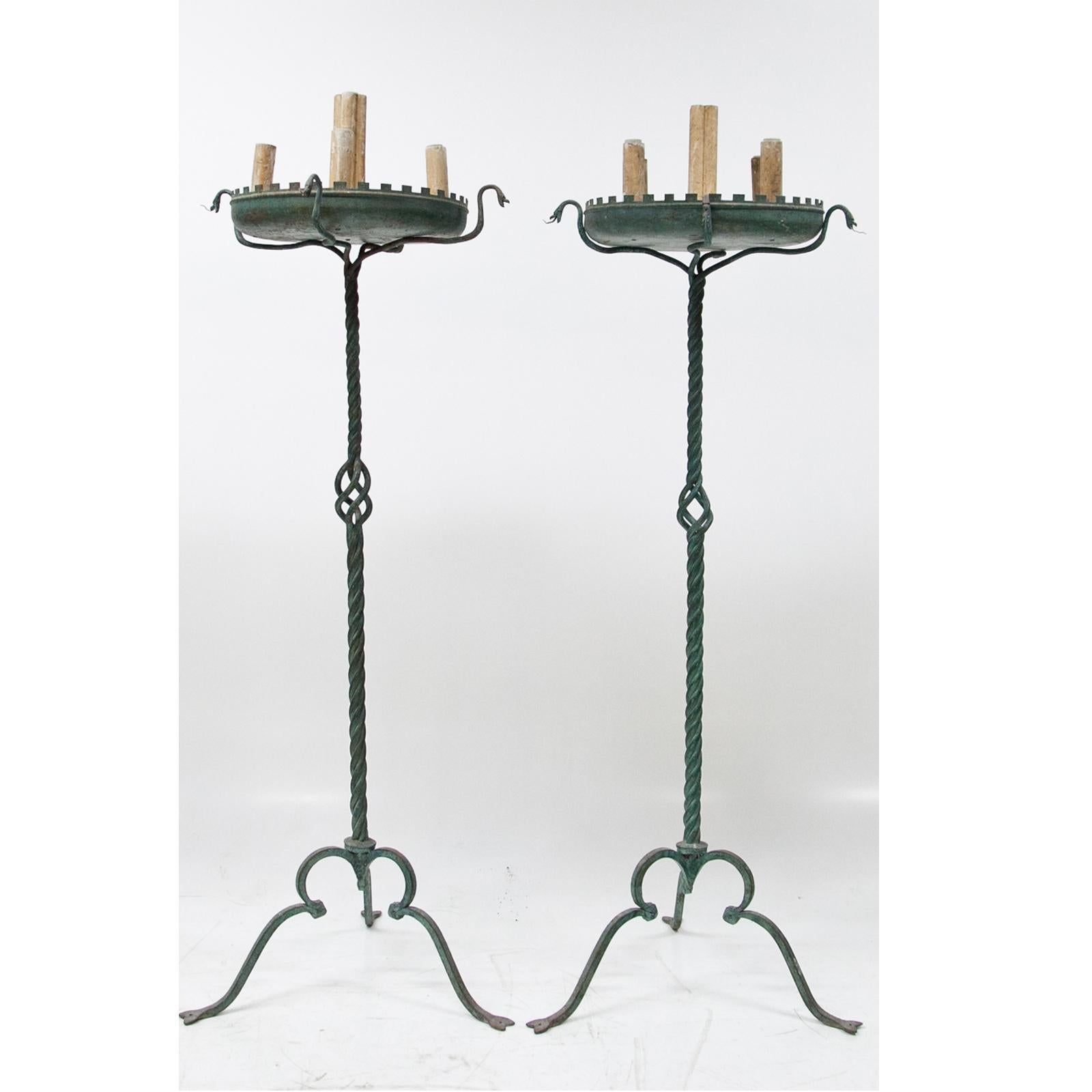 Two large bronze lamps with a twisted shaft and broad dish, resting on stylized snakes. With five sockets in total. The tongues of the snakes are partly missing.