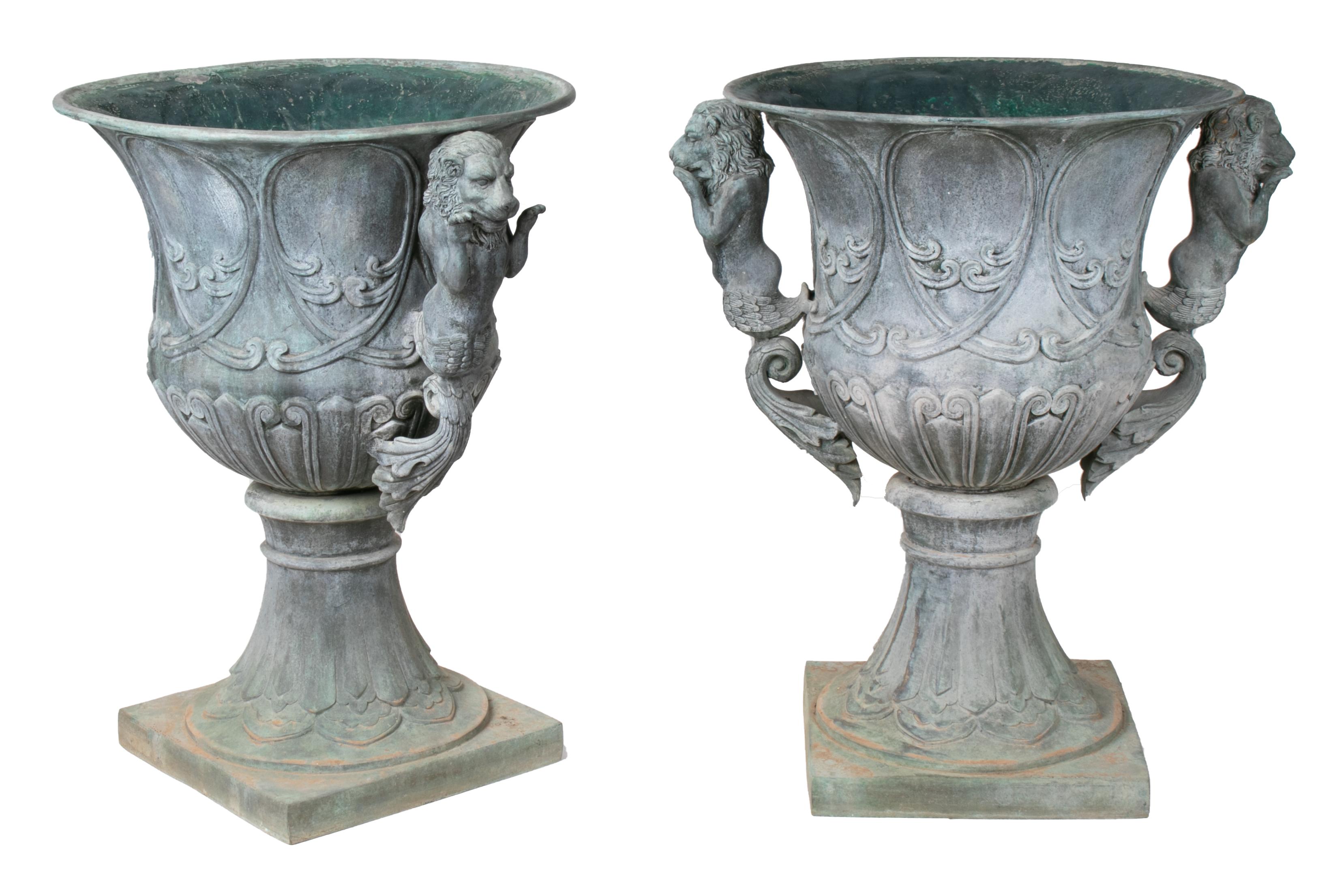 Pair of bronze garden urns with lions in old green patina.