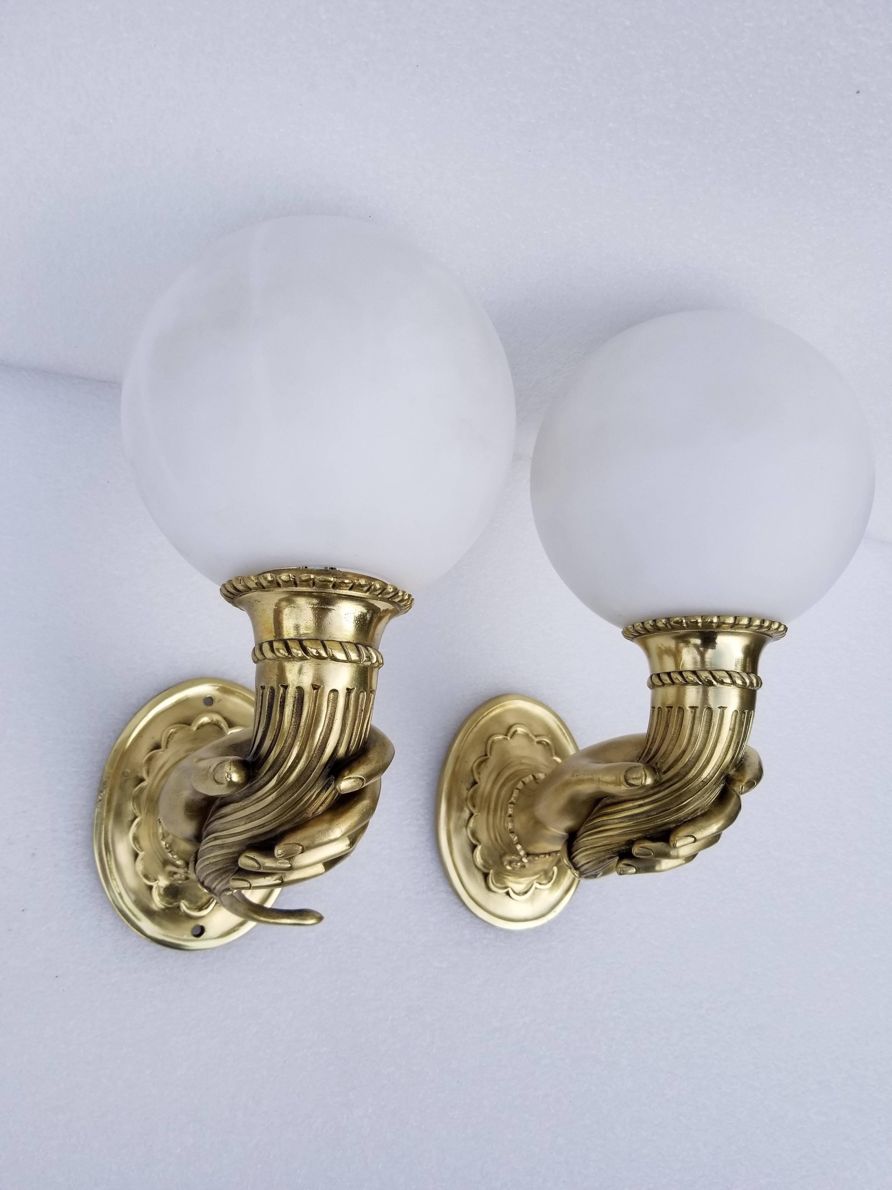 Superbe pair of bronze sconces figuring A feminine hand holding a cornucopia, rare model from 1940.
Refinished and US rewired, 60 watts max bulb. New opaline globe.
Back plate dimensions: 5 H, 4 W.
 
