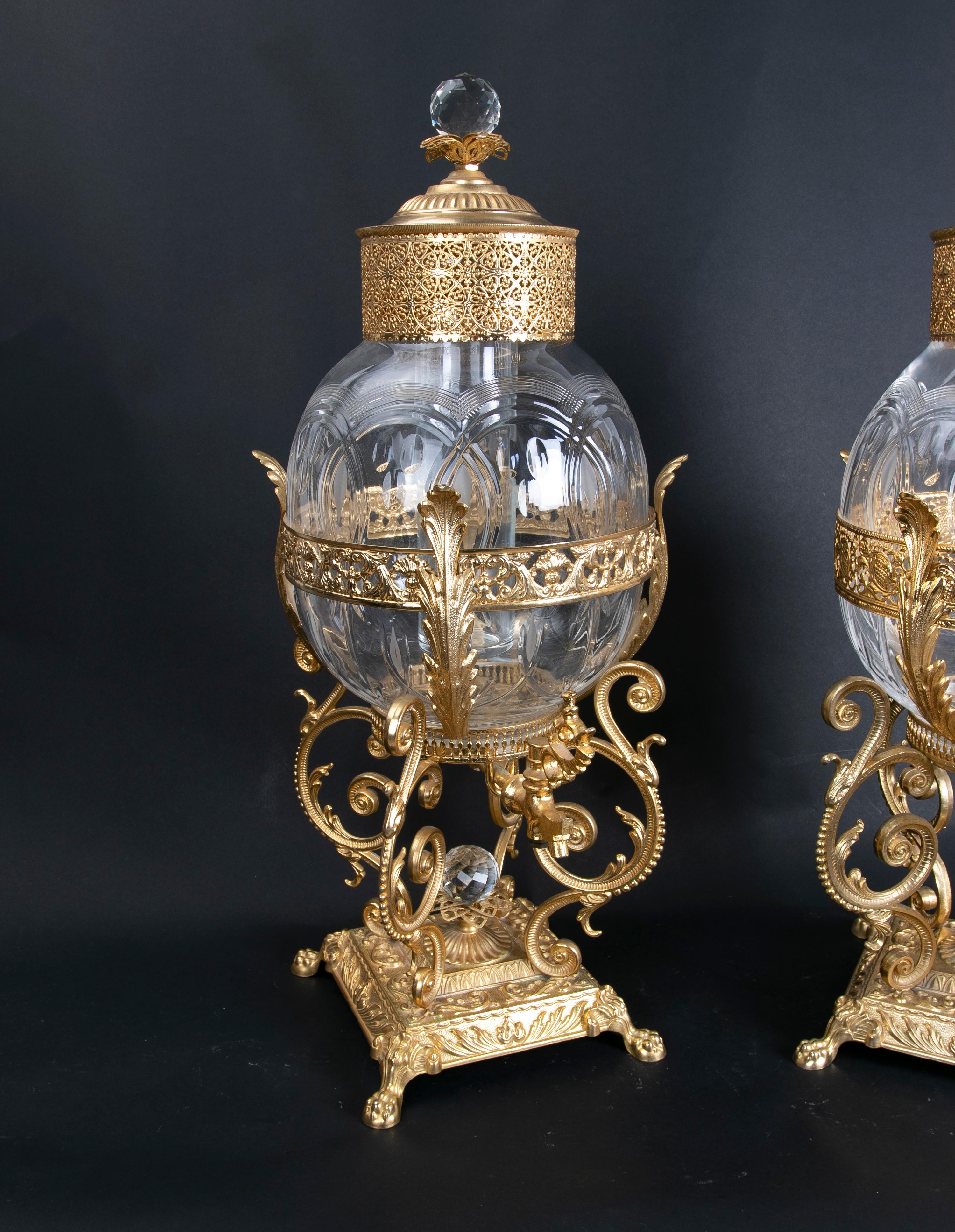 Pair of bronze jars holding lidded glass container.