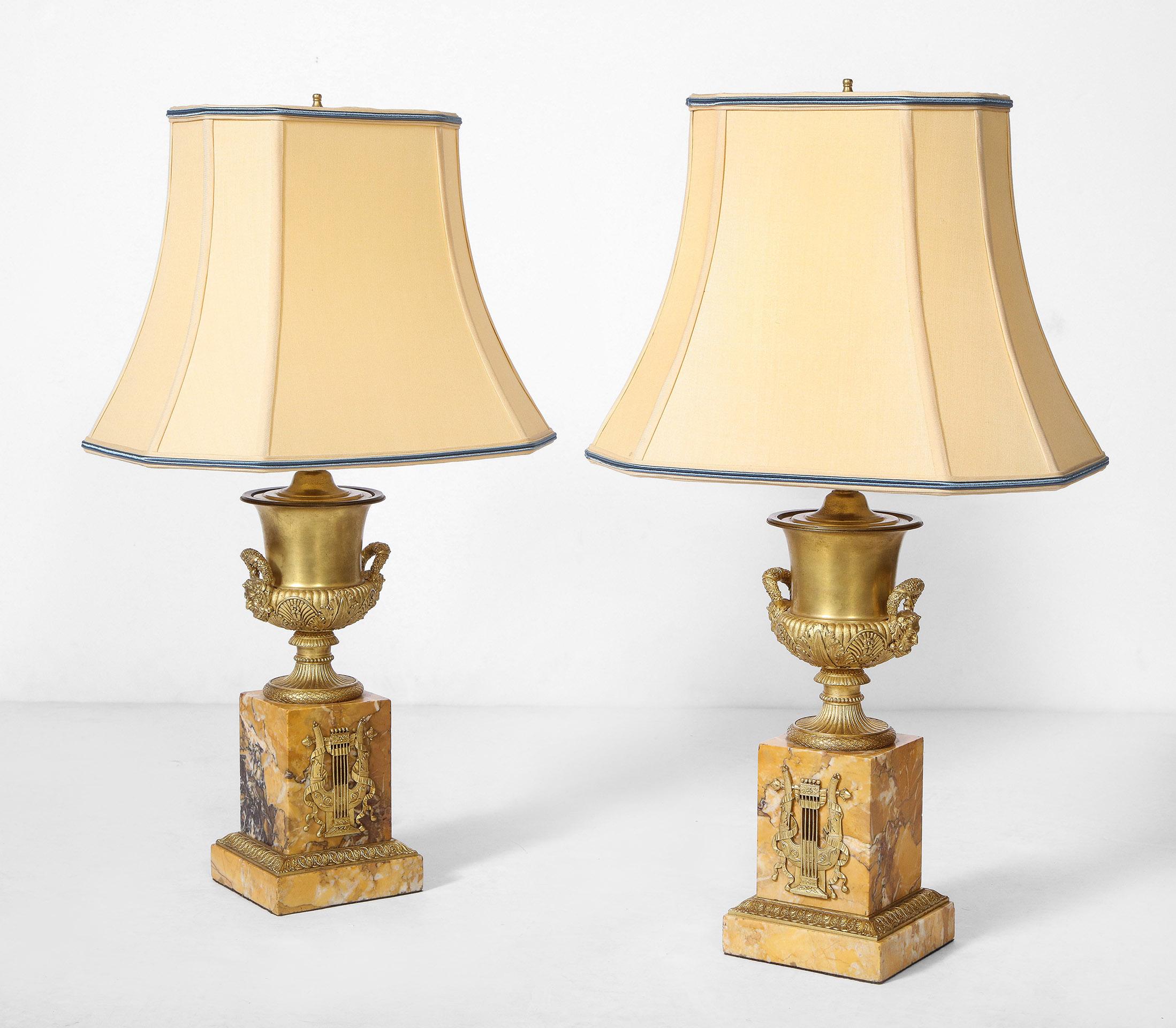 Pair of French Empire style bronze urn lamps

Pair of French Empire style bronze urns converted to lamps. The doré bronze urns with embossed neoclassic motifs on sienna marble bases with lyre appliqué.

The lamps have been recently wired.