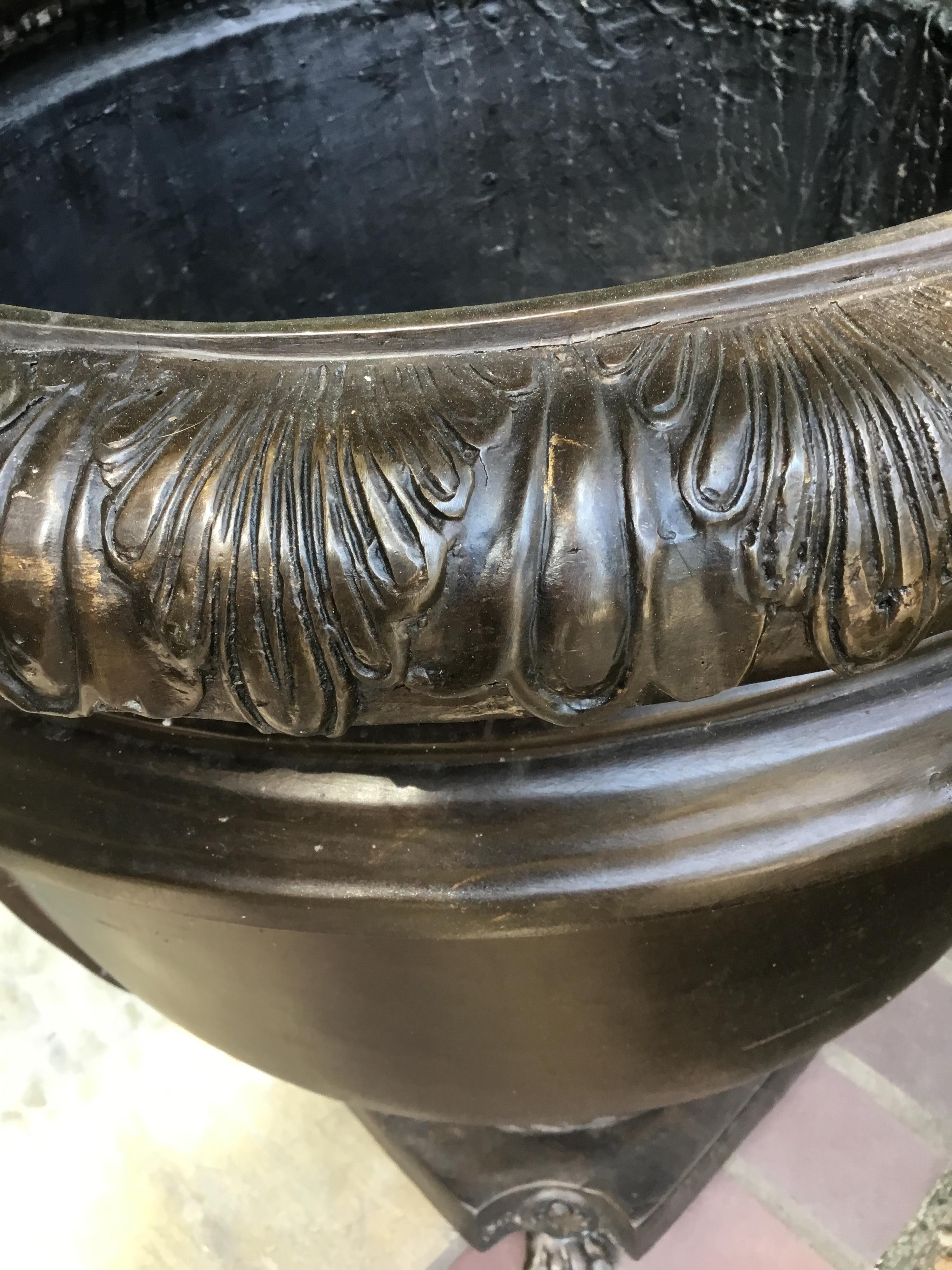 Handsome pair of urn shaped planters with embossed leaf
Collars tapering to laurel and ribbon-bound bases and
Animal paw feet.