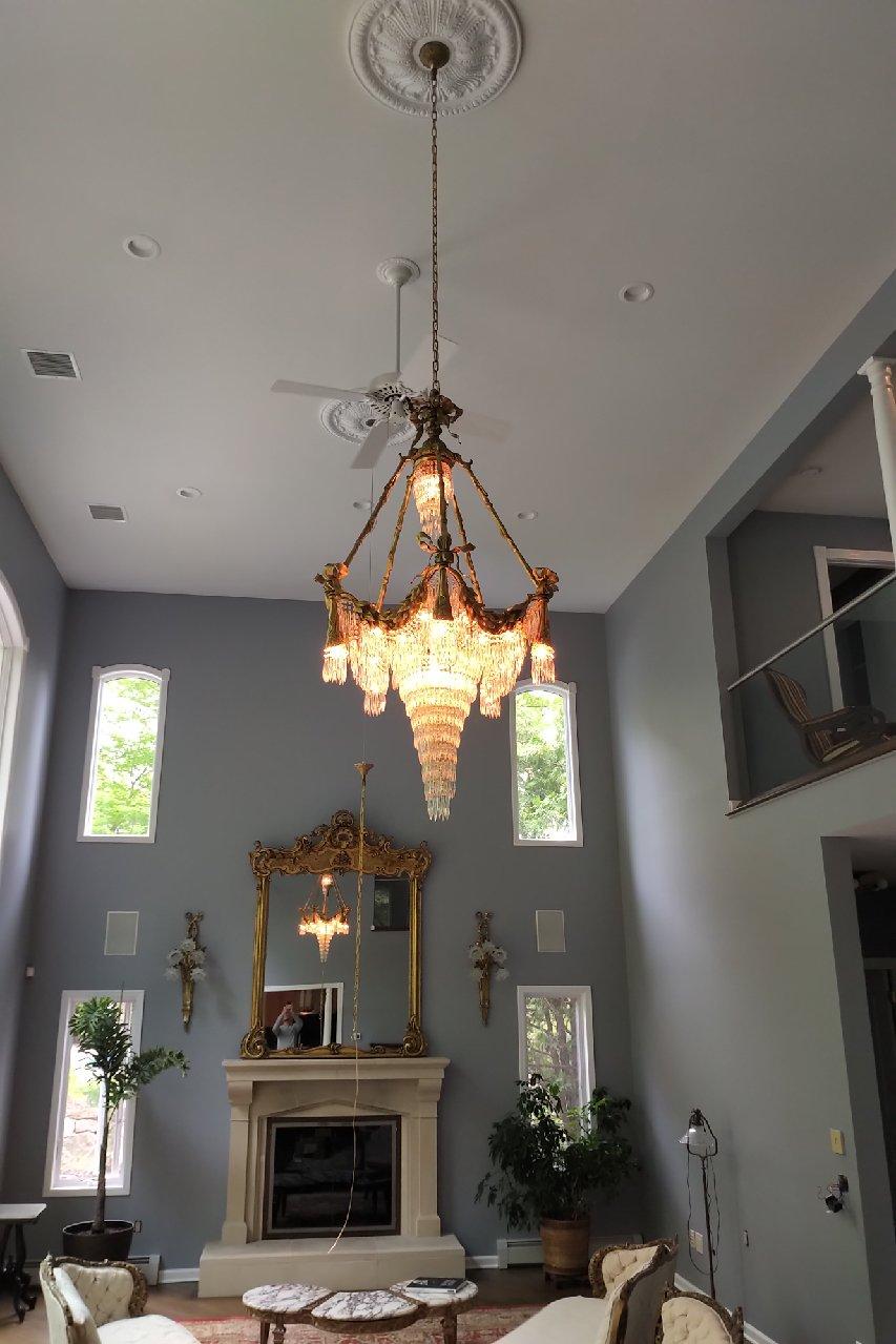 A pair of Bronze Louis XVI style crystal ribbon and tassle drapery chandeliers with 18 lights. Each newly wired. This fine custom quality pair of chandeliers are simply stunning and are certain to light up any area of the home. The ribbon and tastle