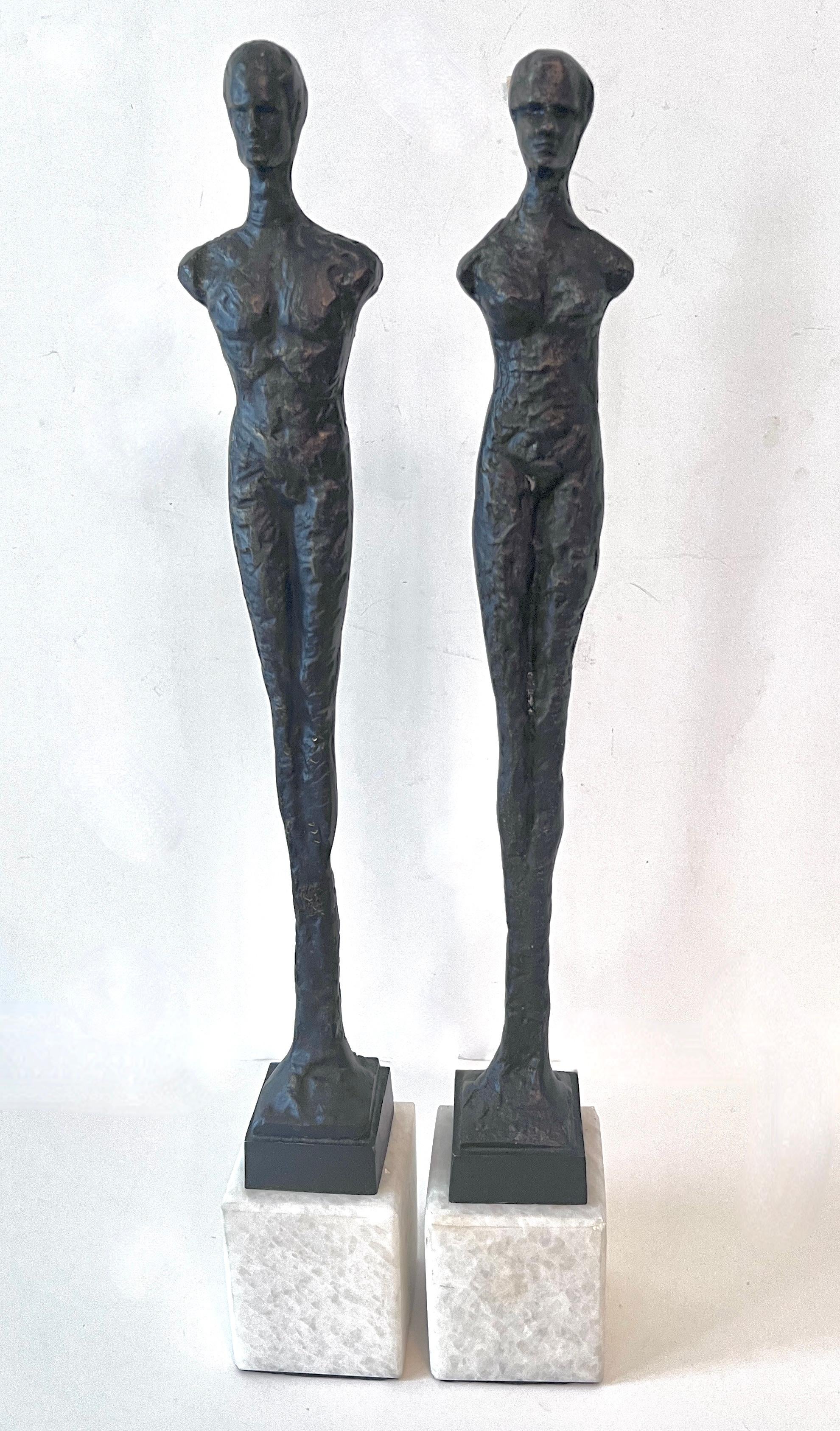 A pair of Bronze Statues in the style of Giacometti.  The pair are Male and Female figures, cast of Bronze and sit atop a White Marble base

A wonderful example of Giacometti's work and style.   A compliment to traditional or Modern space and can