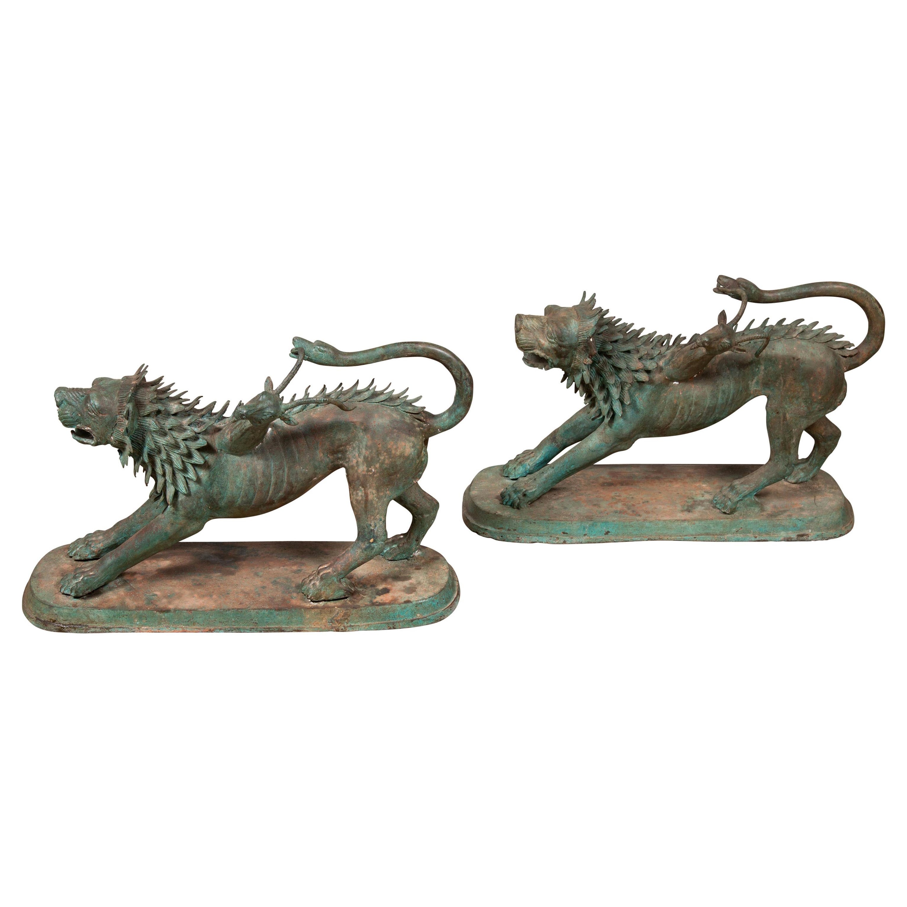 Paire de sculptures d'animaux gardiens mythologiques en bronze à patine vert-de-gris